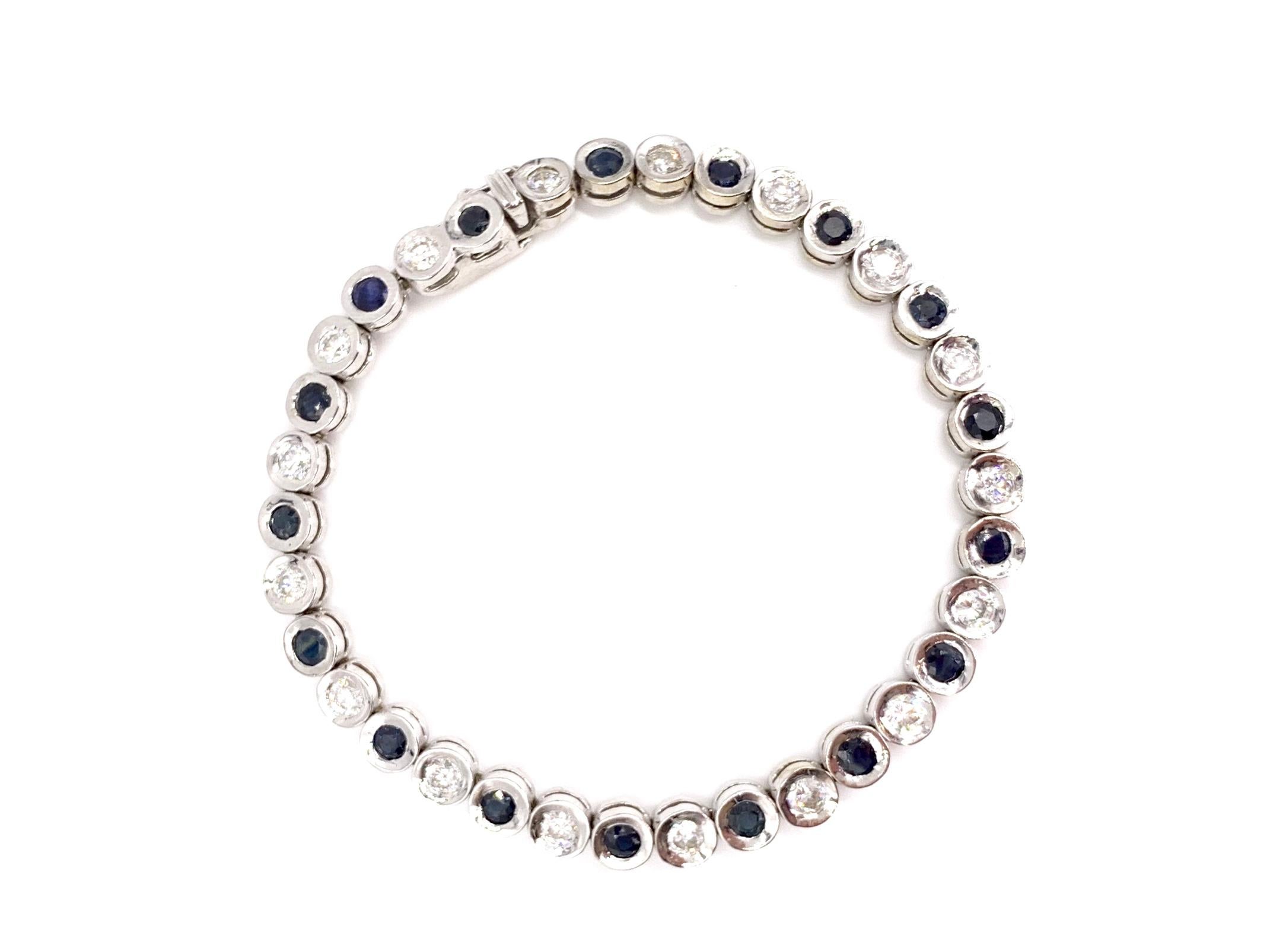 A wearable contemporary 14 karat white gold bezel set alternating round deep blue sapphire and white diamond tennis bracelet featuring 17 diamonds at approximately 1.70 carats total weight and 17 blue sapphires at approximately 2.04 carats total