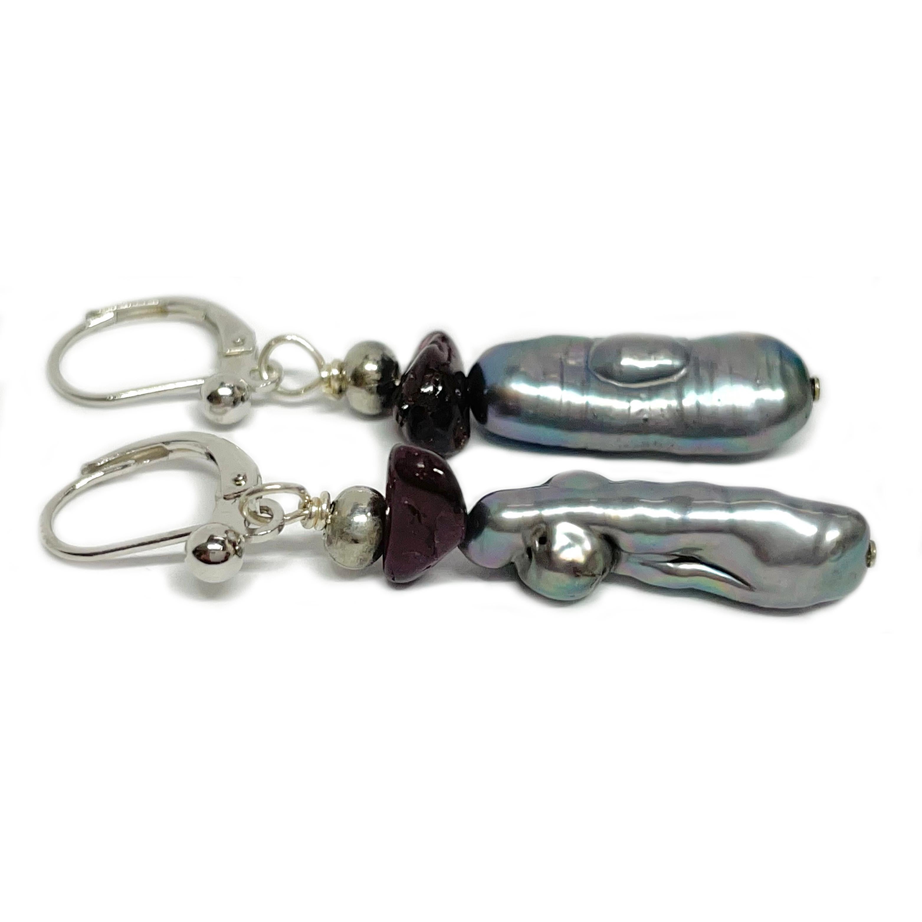 These custom lever-back dangle earrings feature a harmonious blend of materials, creating a unique and eye-catching design. Each earring is adorned with silver Biwa pearls, two 4mm round white gold ball beads, two free-form garnet beads, and a