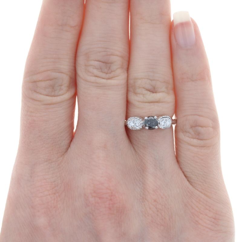 As unique as your romance, this beautiful wedding set includes an engagement ring with a color-enhanced black diamond solitaire in a basket-style mounting. Pairs of white diamonds in oval-shaped mountings bordered in beaded detailing flank the