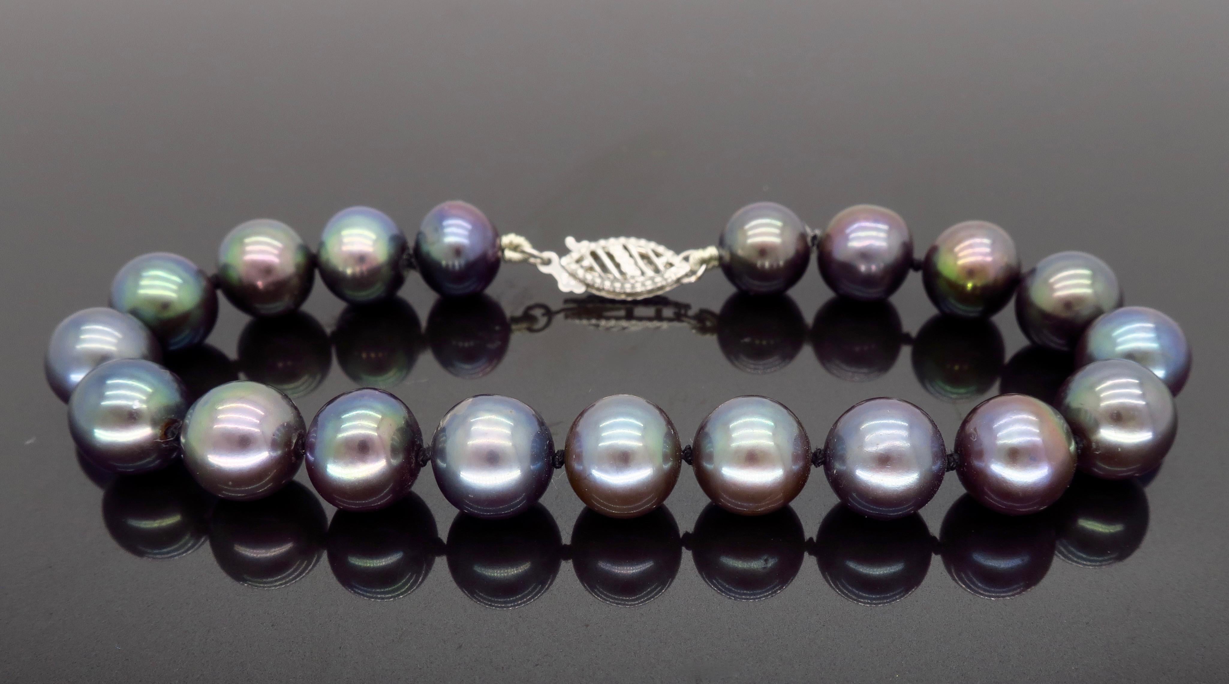 Beautiful black pearl bracelet with a stunning play of iridescent color, and ornate white gold clasp.

Gemstone: 19 Round Black Pearls
Gemstone Size: Approximately 8.6mm Round
Metal: 14K White Gold
Marked/Tested: Stamped “14K