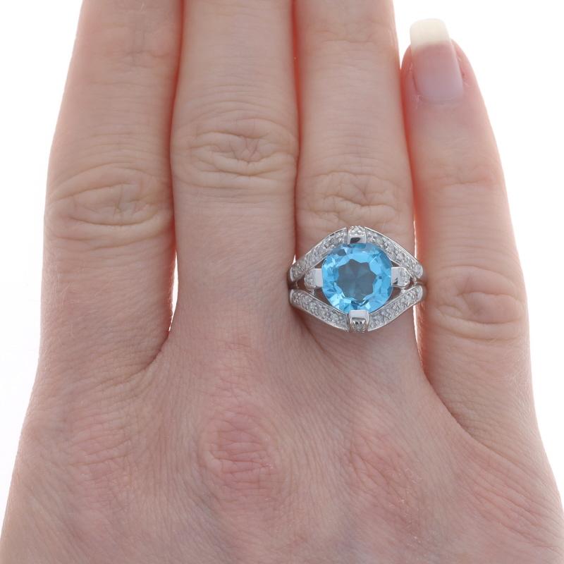 Size: 7
Sizing Fee: Up 1 size for $35

Metal Content: 10k White Gold

Stone Information
Natural Blue Topaz
Treatment: Routinely Enhanced
Carat(s): 3.05ct
Cut: Modified Round

Natural Diamonds
Carat(s): .20ctw
Cut: Single
Color: H - I
Clarity: I1 -