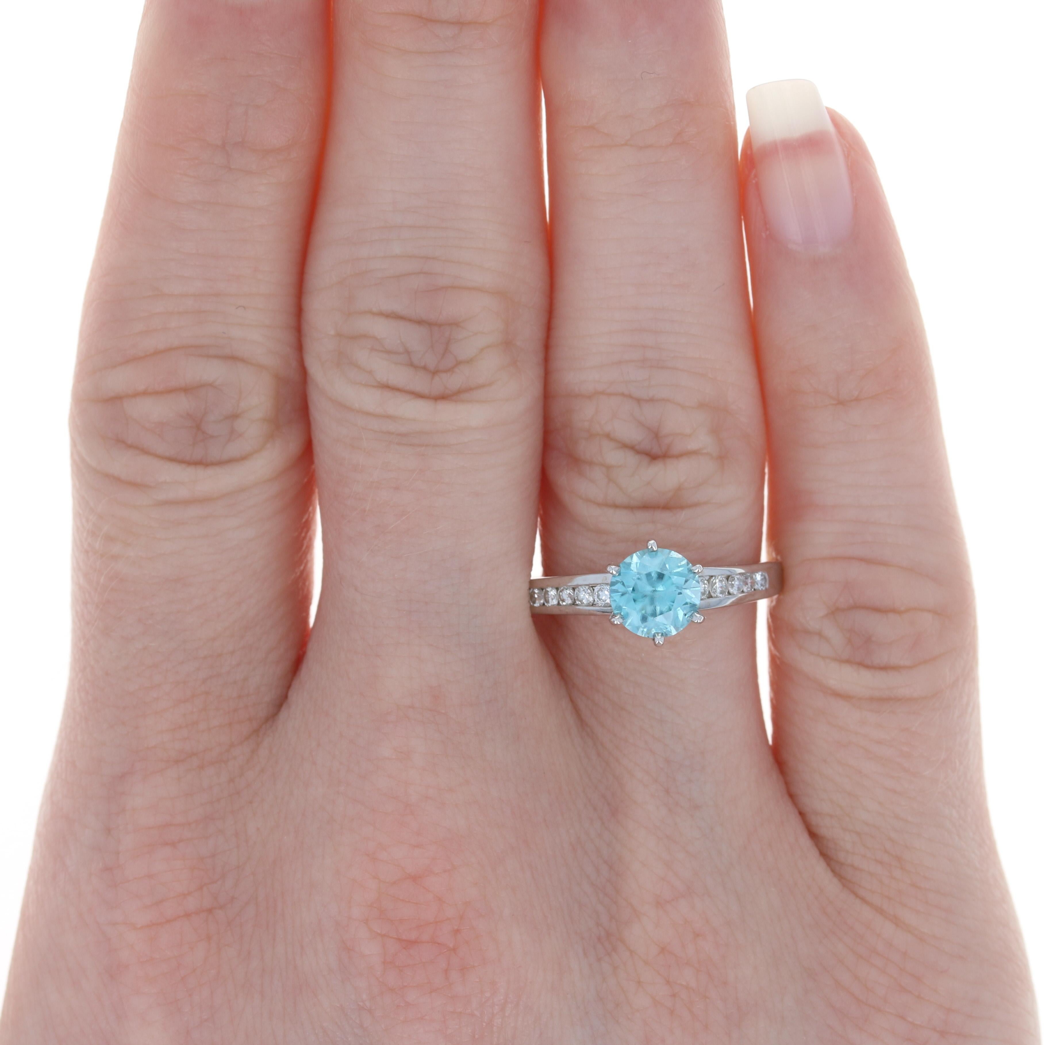 Size: 7 3/4
Sizing Fee: Down 2 sizes for $20 or Up 2 sizes for $25

Metal Content: 14k White Gold

Stone Information: 
Genuine Zircon
Carat: 1.59ct (weighed)
Cut: Round Brilliant
Color: Blue
Diameter: 6.5mm 

Natural Diamonds
Carats: .24ctw
Cut: