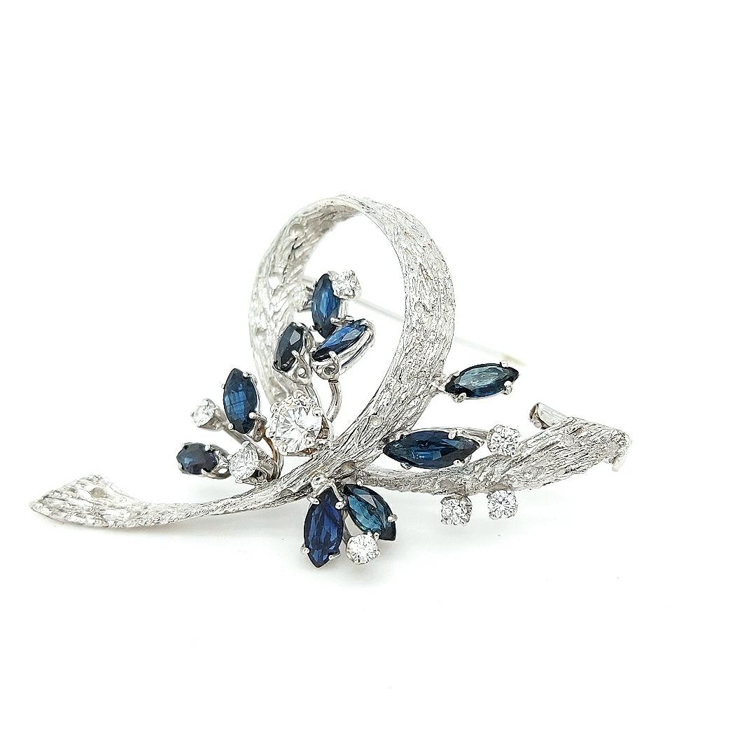 Attractive 18kt solid white gold brooch set with diamonds and sapphires.

Fine and glamorous brooch to make you sparkle on every occasion.

Diamonds: Brilliant cut diamond, together 0.90 carat

Sapphires: 9 Marquise cut sapphire precious stones,