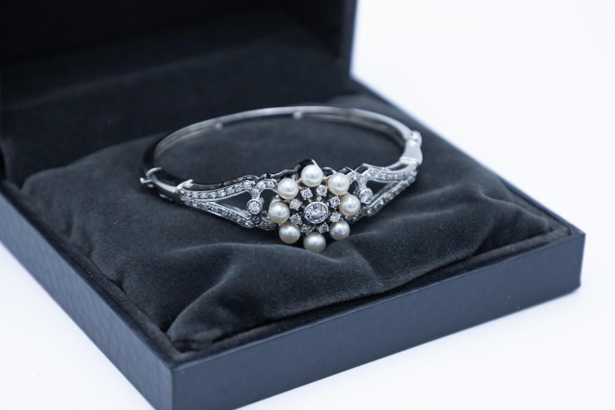 Magnifique bracelet rigide en or blanc 14 carats.

Décoré au centre d'un losange et d'un cramoisi perlé.

Origine : Scandinavie, produit contemporain

Sertie de diamants taille brillant d'un poids total d'environ 1,28ct. et d'une couronne de 8