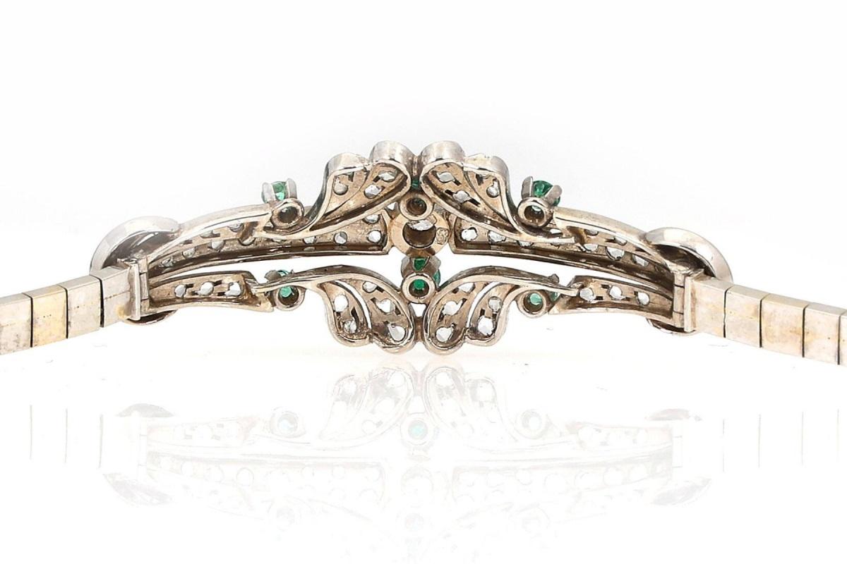 Bracciale antico in oro bianco 18 carati.

Bracciale a maglie interconnesse. Decorato sul davanti con sei smeraldi rotondi per un peso totale di circa 0,40 ct, circondati da 67 diamanti taglio rosa per un peso totale di 0,59 ct.

Origine: