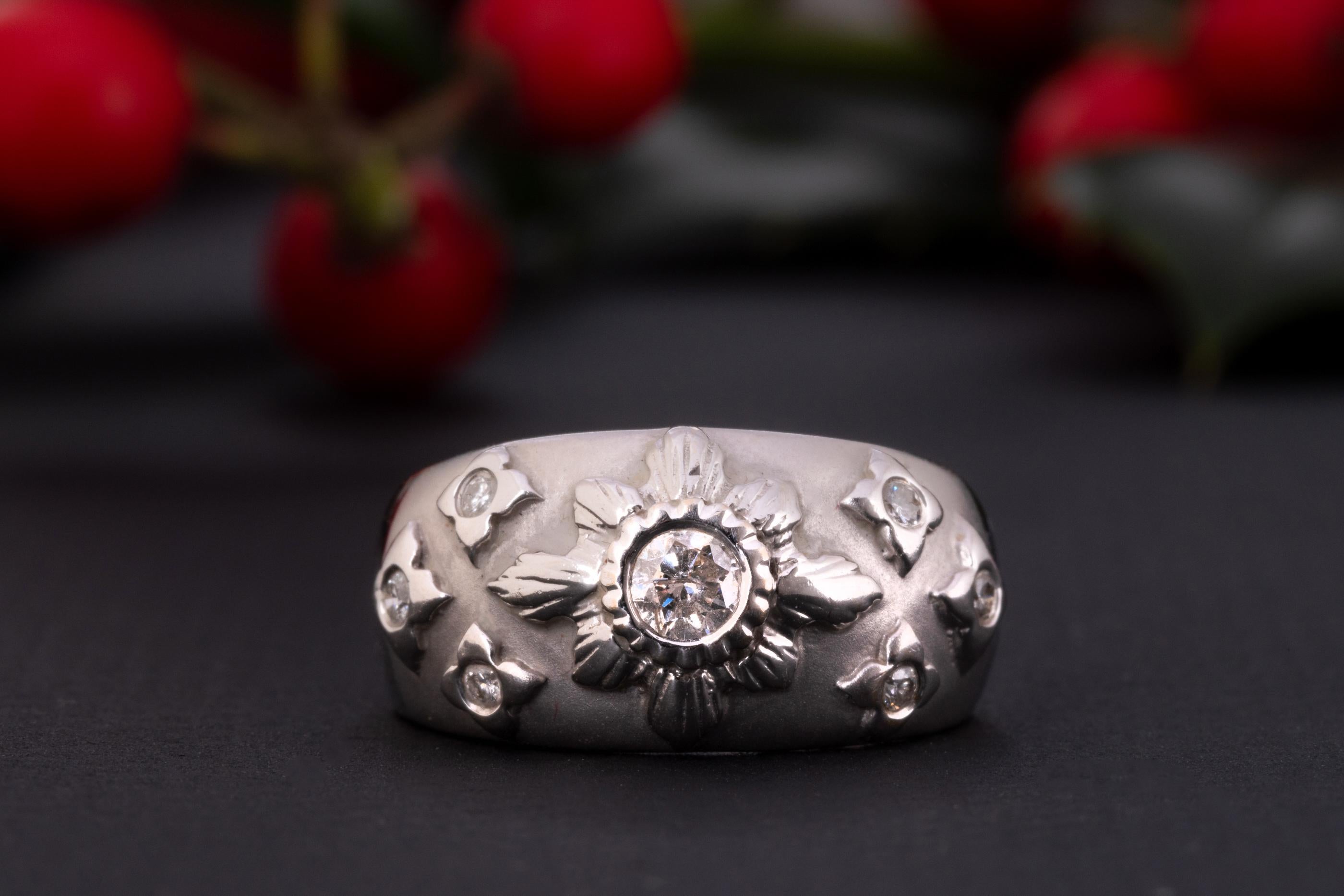 A white gold diamond starburst ring made of solid 18 ct gold and set with 0.35 ct worth of diamonds.

The shank of this celestial ring is rather wide and puffy, the front part is brushed and has a velvet-like gold texture. The celestial centerpiece