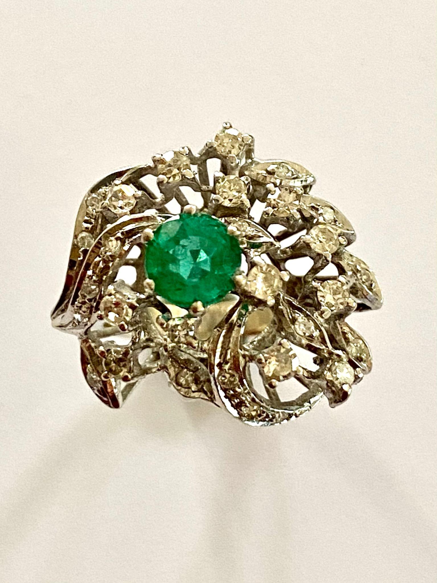 One (1) 18K. White Gold Ring, Stamped:  750 
One (10 Natural Beryl: Emerald = 0.85ct intense Green  Origin: Zambia
29 Diamonds single cut = 0.50 ct. VS/P1  IJK
Model: Fantasie Cocktail.
Made in Germany ca 1960
Weight: 6.74 grams
Size:  16,5 ( 52) 