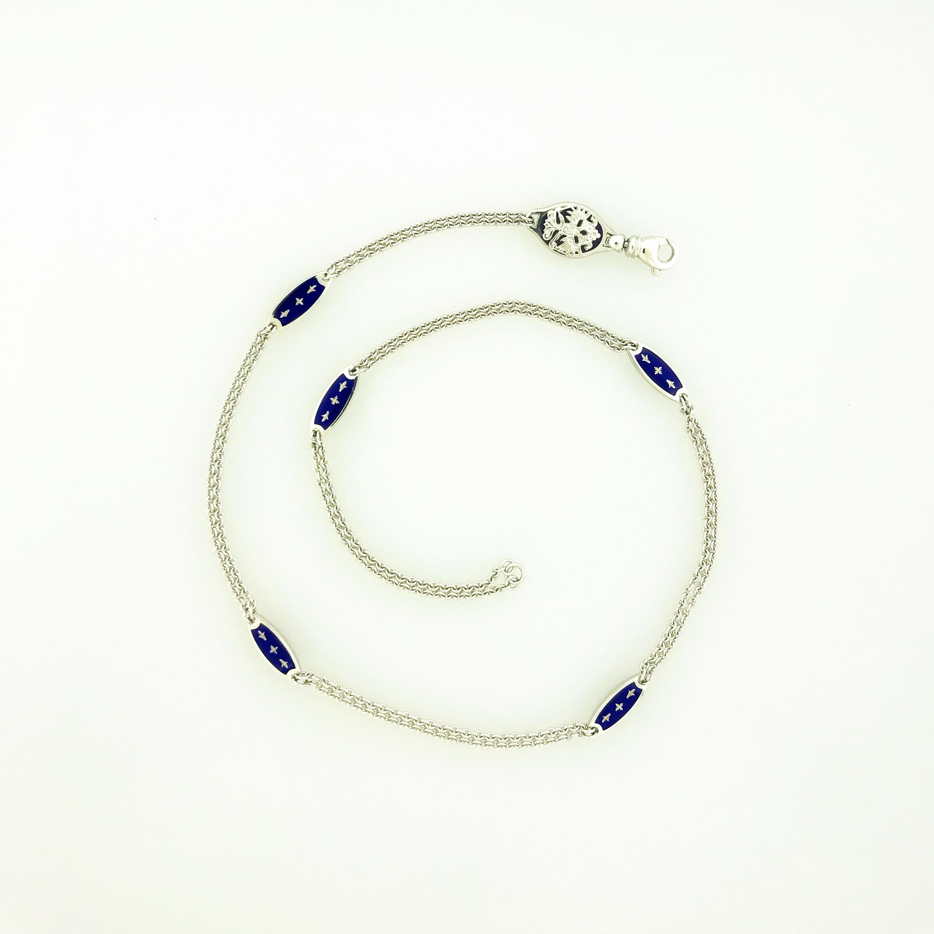 18K white gold limited-edition Fabergé necklace having double fancy link chain between five double-sided cobalt blue enameled oval-shaped elements with 18K white gold decorative paillons, and its Fabergé Crest clasp. The limited-edition chain