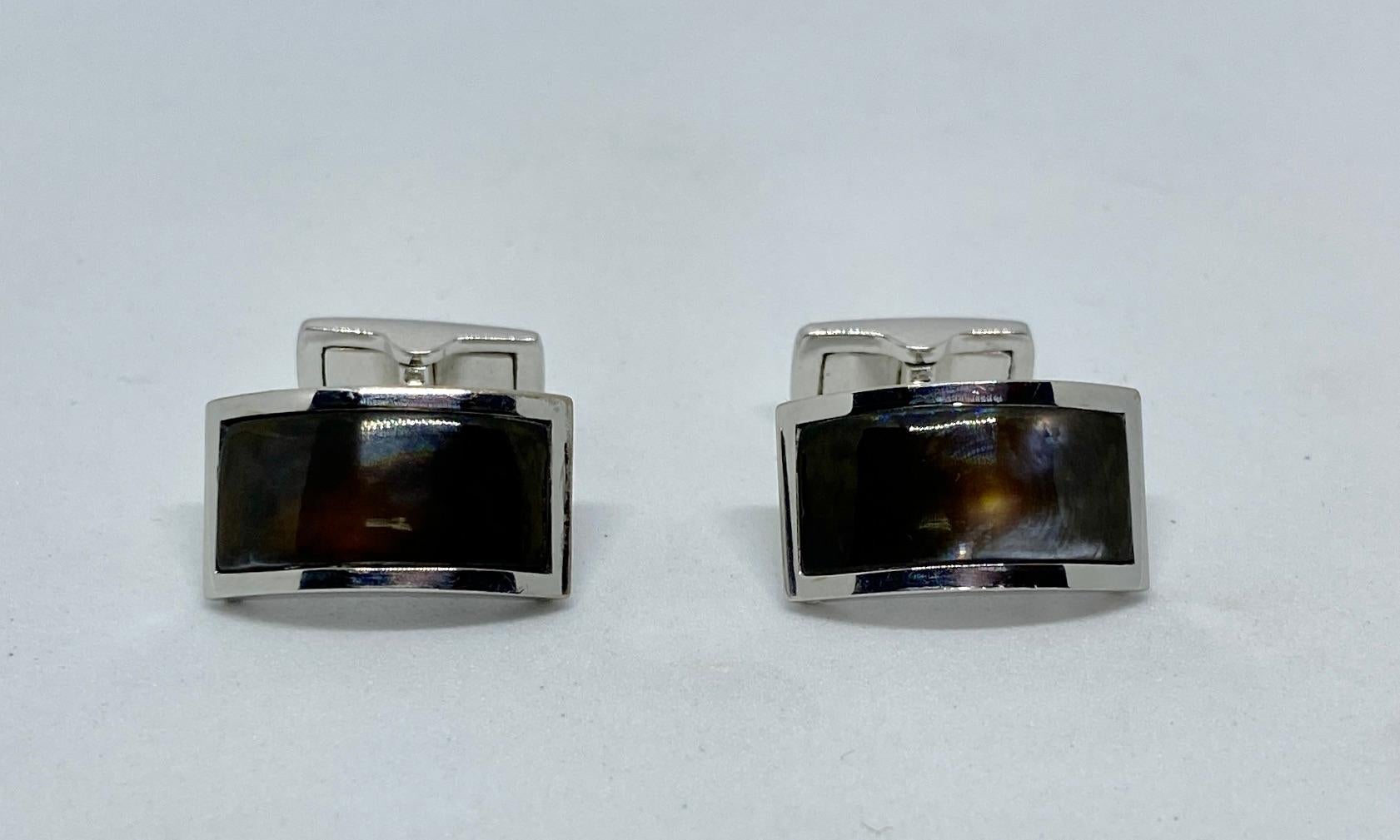 Exceptionally handsome and beautifully made cufflinks by the renowned Swiss jeweler, Gübelin. They're rendered in solid 18K white gold, these rare cufflinks are inset with dark, richly colored abalone.

The rectangular faces are curved; the toggle