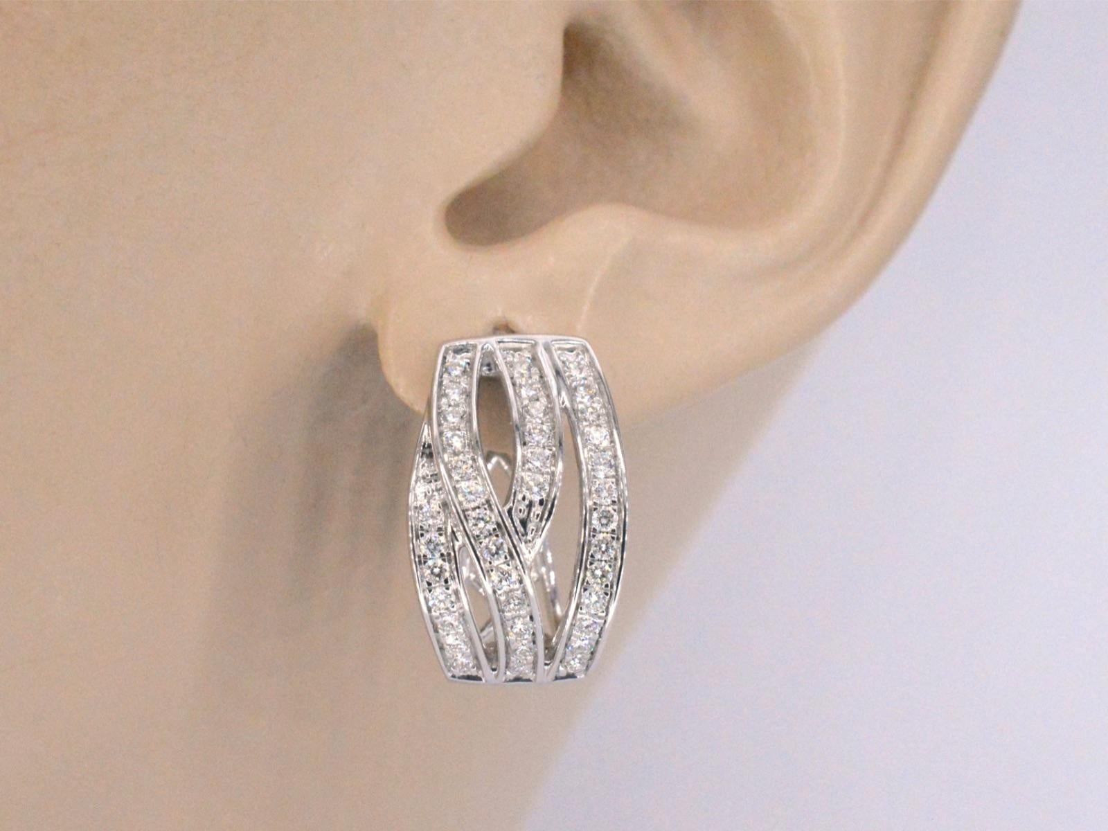 Ces boucles d'oreilles en or blanc sont un superbe bijou qui présente des diamants de taille brillante dans un design unique et moderne. Les diamants sont sertis de manière experte dans l'or blanc pour créer un look homogène et sophistiqué, parfait