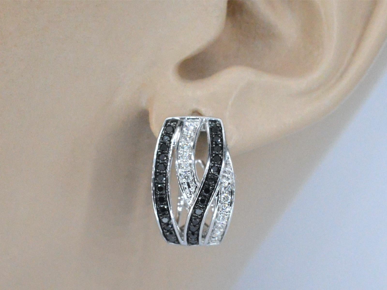 These 18K white gold earrings are a unique and stylish design featuring a combination of white and black brilliant diamonds of high quality. The white gold is a premium quality metal that is highly lustrous and durable. The diamonds used in the