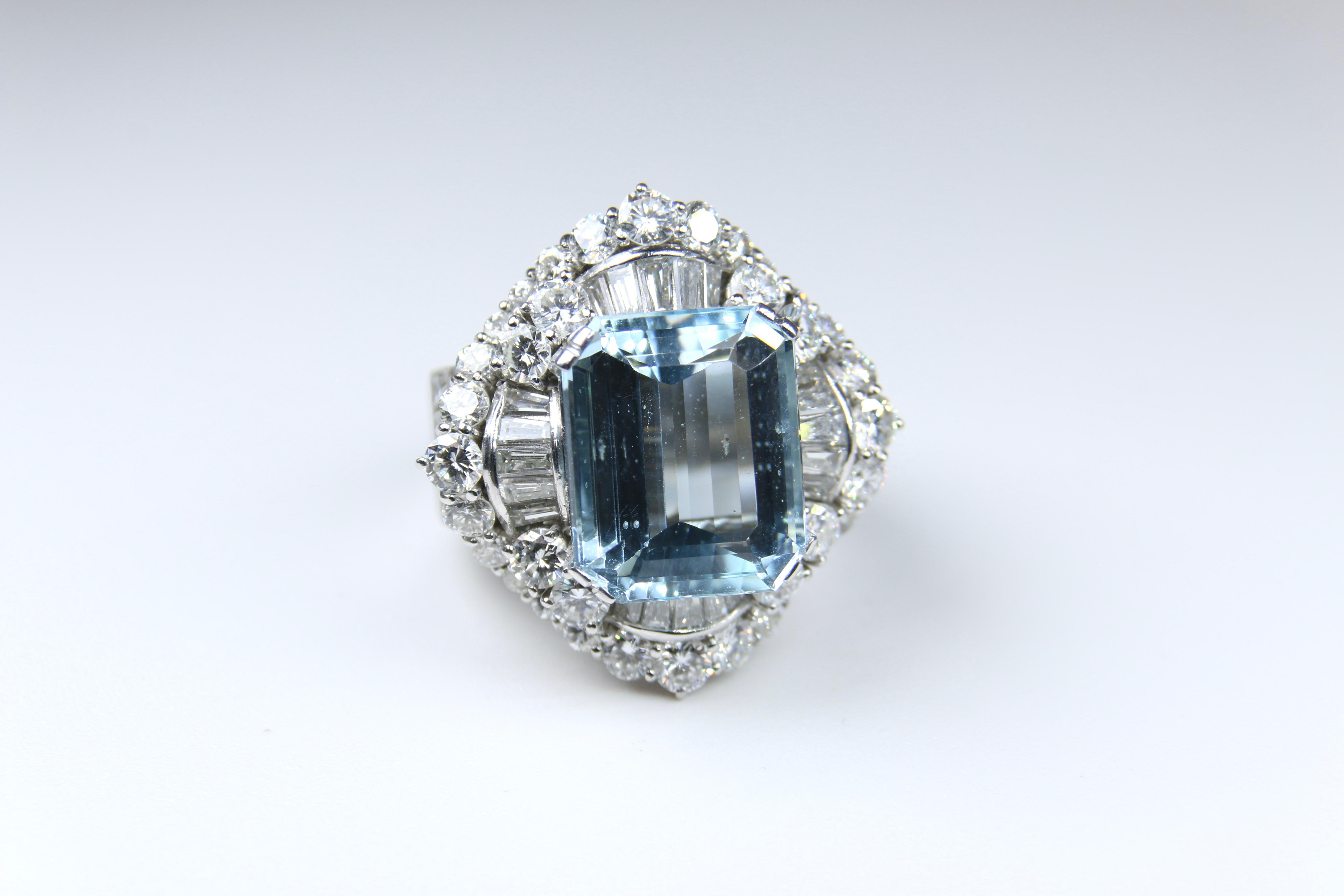 Stunning White Gold Setting with Diamonds and a fabulous Aquamarine Ring.  A mixture of baguettes and rounds make this cocktail ring quite the conversation piece.  This ring appears to be built for a Queen in all it's majesty. Emerald Cut Aqua Sits