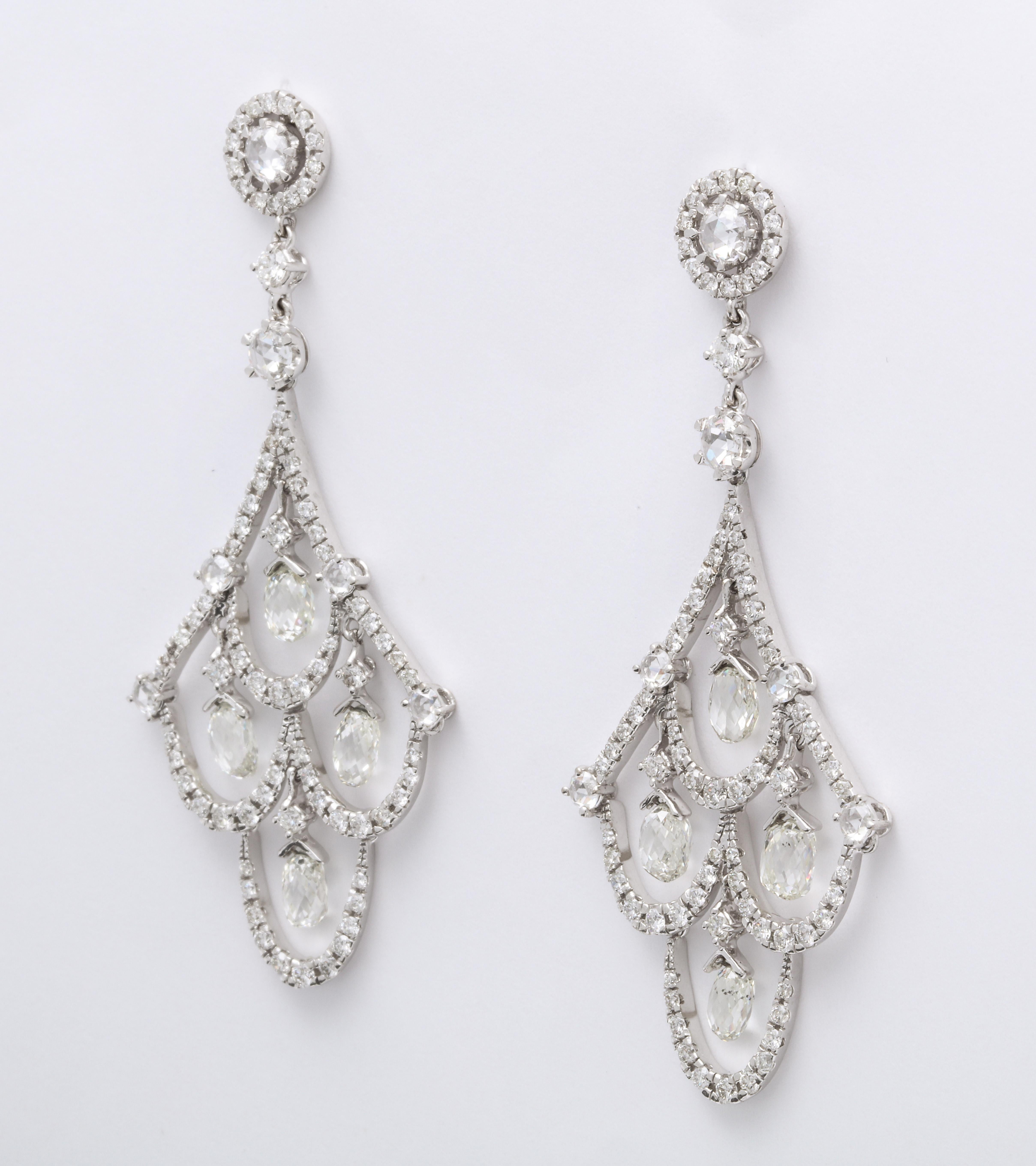 Articulating 18K white gold stylized festoon chandelier ear pendants decorated with pave'-set round brilliant-cut diamonds, mounted with round rose-cut diamond joints, and suspending floating colorless diamond briolettes, combined diamond weight: