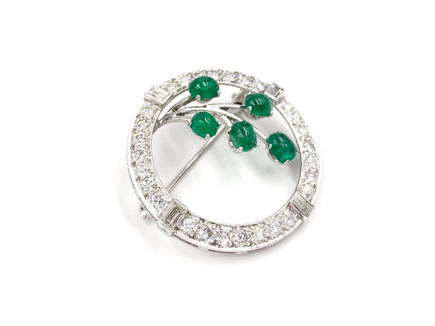 An elegant and wearable 14k white gold diamond and emerald vintage brooch with a beautiful garland branch motif. Circle brooch is composed of approximately 1.25 carats of white round brilliant and baguette cut diamonds at approximately G color, VS2