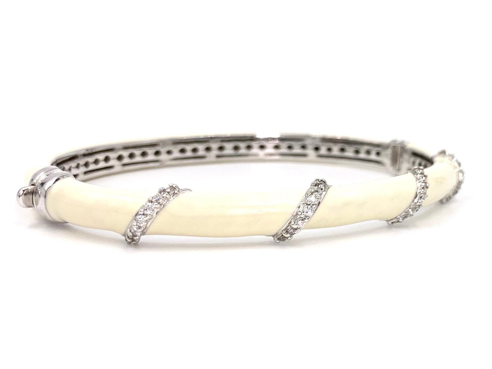 Beautiful and well made 14 karat white gold oval bangle bracelet featuring hand painted ivory/cream color enamel and .35 carats of white diamonds. Diamond quality is approximately G color, VS2 clarity. Bracelet features an easy to use push-button