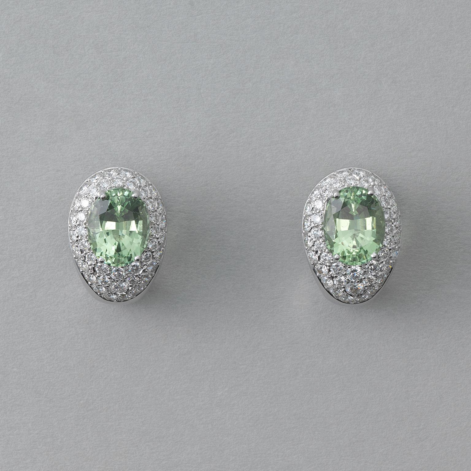 A pair of egg-shaped ear clips, 18 carat gold rhodium plated, pavé set with 84 diamonds (app. 2.14 carat in total) set with oval facetted natural mint green tourmalines (app. 7.03 carat in total), unworn, modern.
 
weight: 12.96 grams
dimensions: