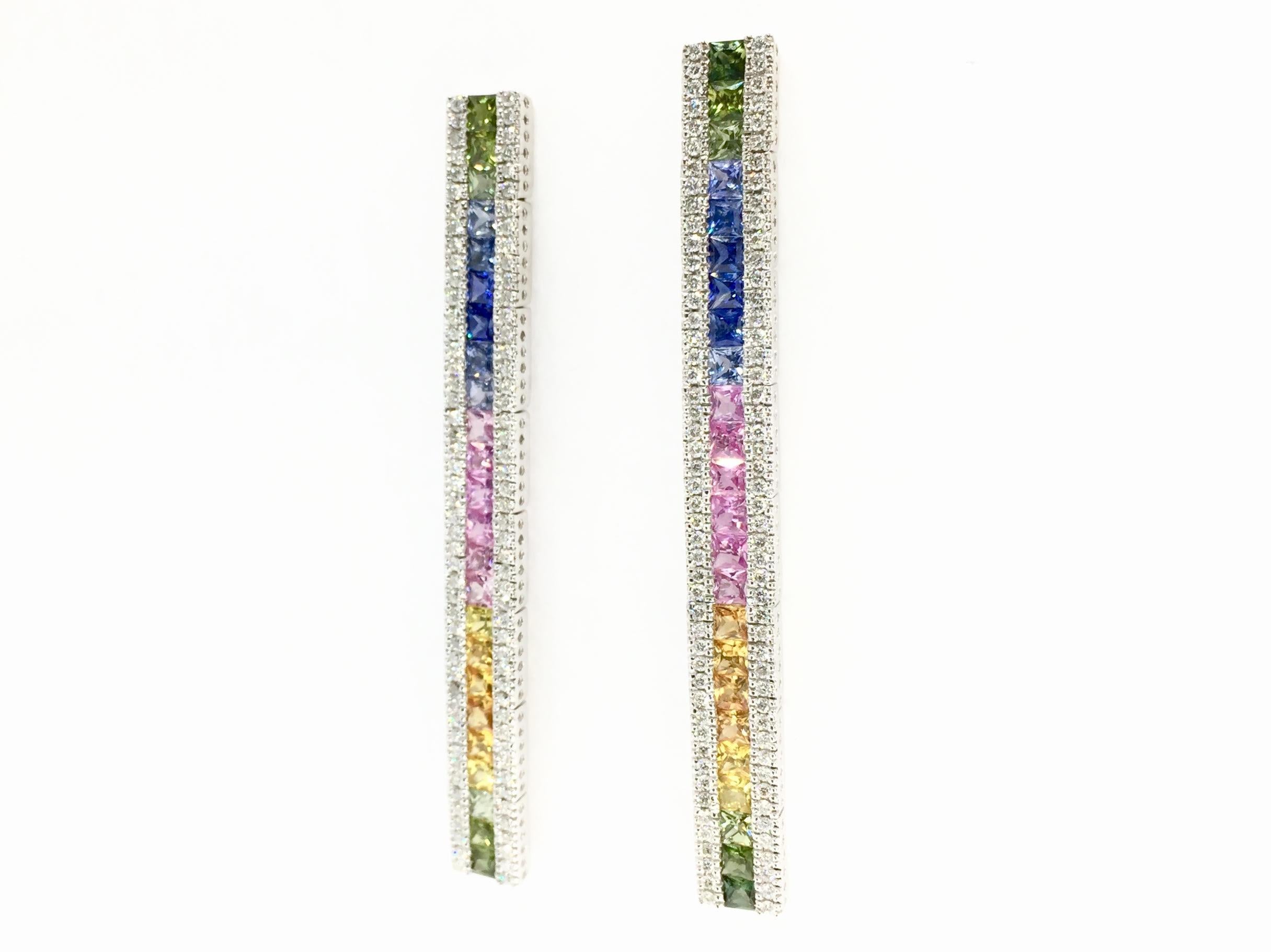 Colorfully vivid sapphire and diamond long drop earrings made in 14 karat white gold. Earrings feature approximately 1.20 carats total weight of round brilliant diamonds at approximately G color, SI1 clarity. Princess cut sapphires are arranged in a