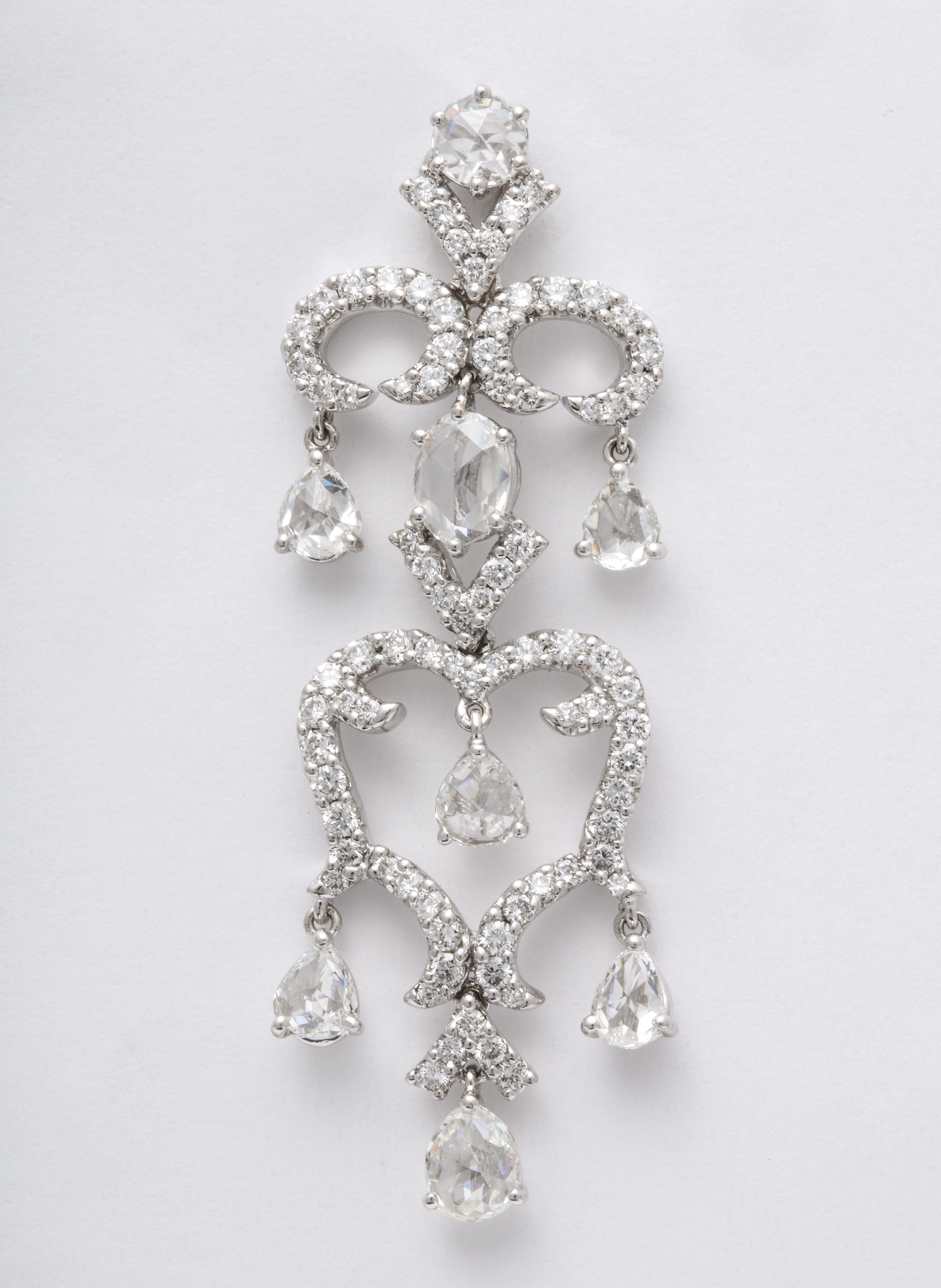 Articulating 18K white gold stylized chandelier earrings decorated with pave'-set round brilliant-cut diamond branches, suspending pear-shape and oval rose-cut diamond drops: 5.13 carats total diamond weight.
These earrings are for pierced ears