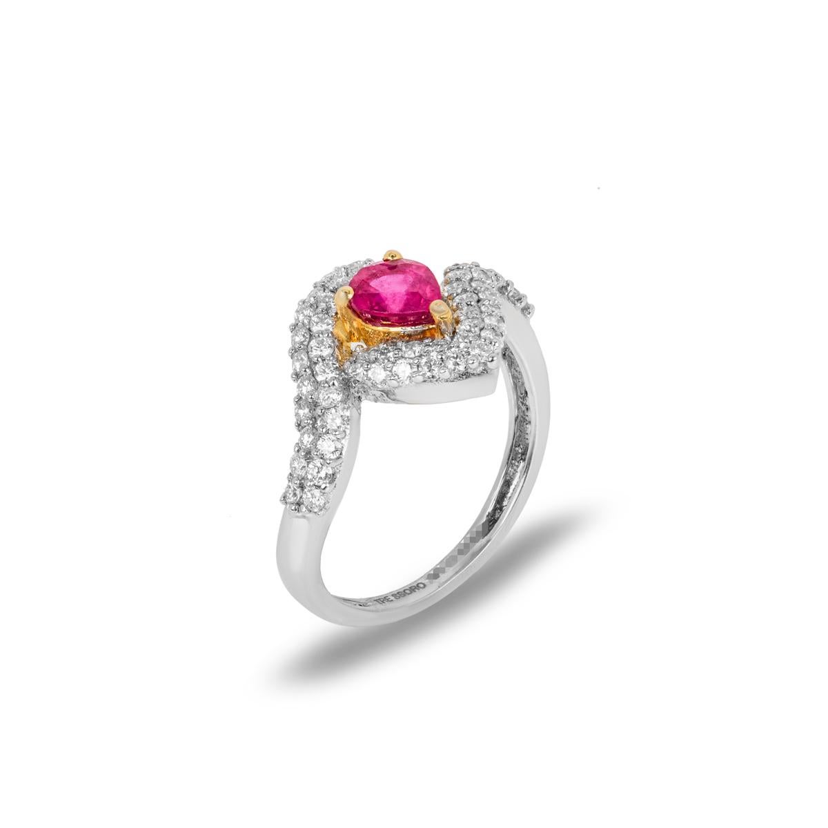 Ein atemberaubender Kleiderring aus 18 Karat Weißgold mit Rubinen und Diamanten. Der Ring ist in der Mitte mit einem Rubin im Birnenschliff von 0,85 Karat besetzt, der eine gleichmäßige, satte Farbe aufweist. Der Rubin ist von 2 Reihen runder