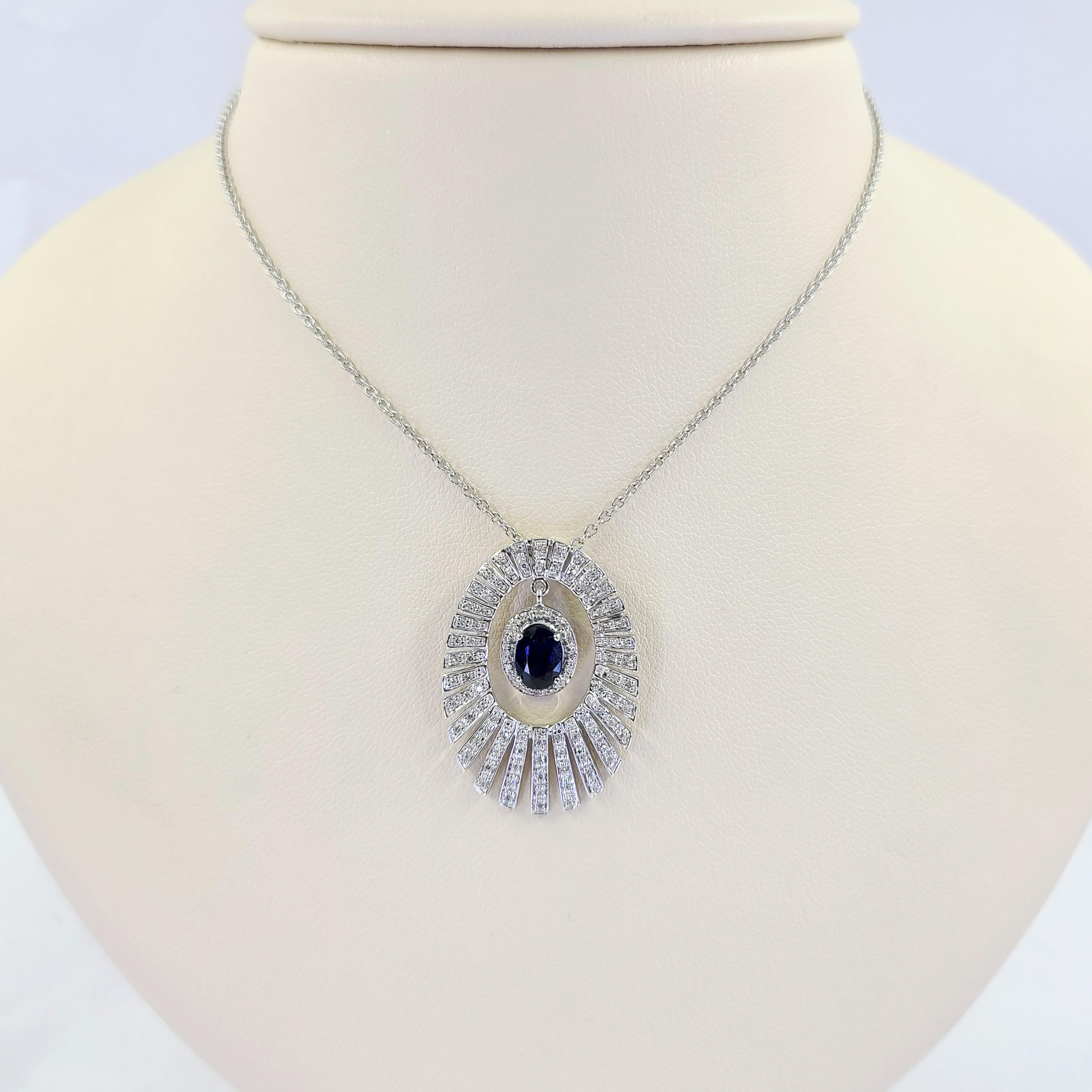 14 Karat White Gold Burst Pendant Necklace Featuring A 1 Carat Oval Sapphire Surrounded By 61 Single Cut Diamonds of SI Clarity and G/H Color Totaling 0.30 Carats. 16 Inch Chain with 1.25 Inch Pendant. Finished Weight Is 6.6 Grams.