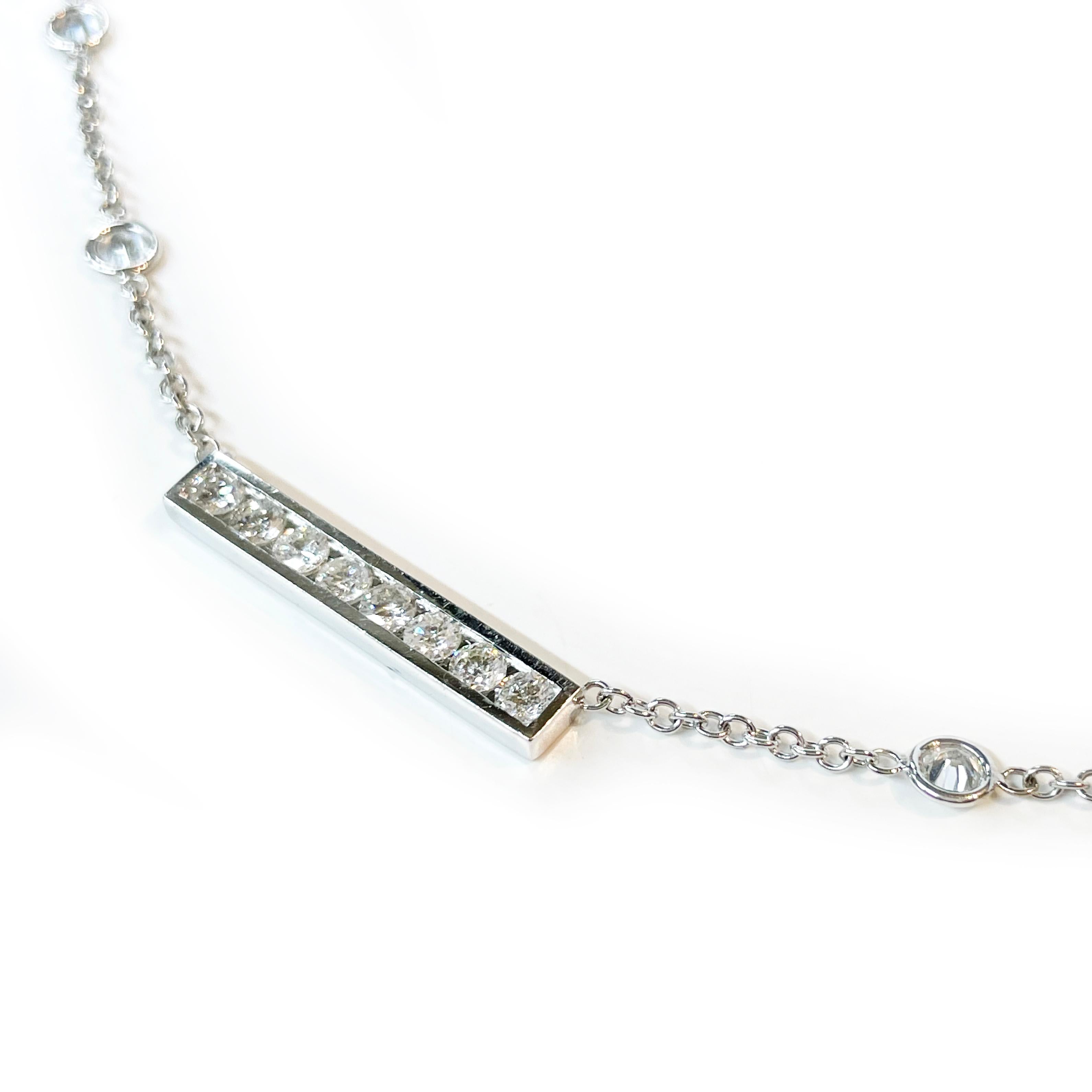 White Gold Bar Diamond Station Necklace. Eight exquisite 3mm diamonds are channel-set in a diamond bar at the bottom of the necklace. Eight 3.4mm diamonds are bezel-set in circle stations approximately an inch apart on the lower half of the