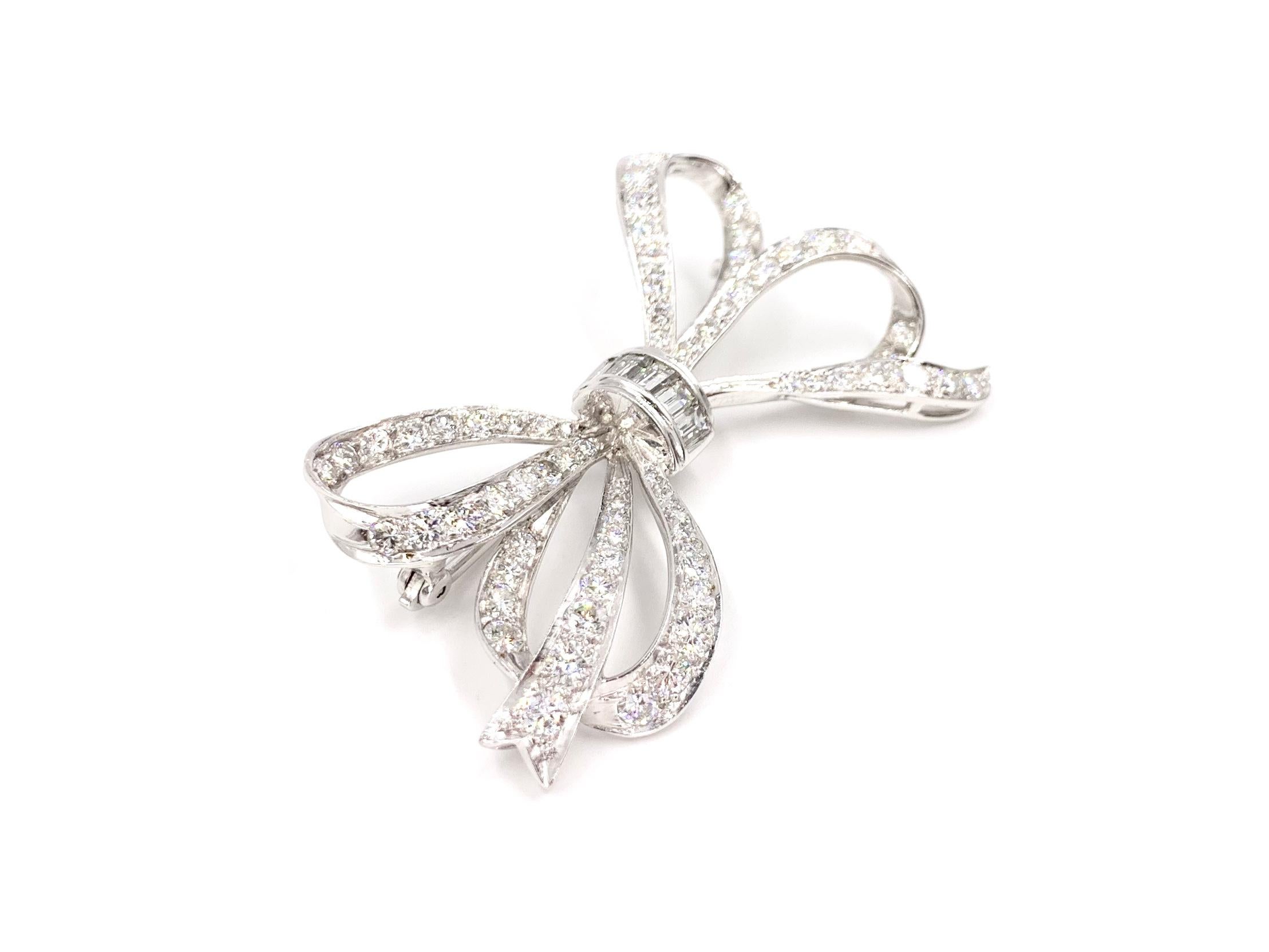 An elegant 14 karat white gold flowing bow brooch with round brilliant and substantially sized baguette diamonds at approximately 2.50 carats total weight. Diamond quality is approximately G-H color, SI1 clarity.
Brooch measures 55mm width across