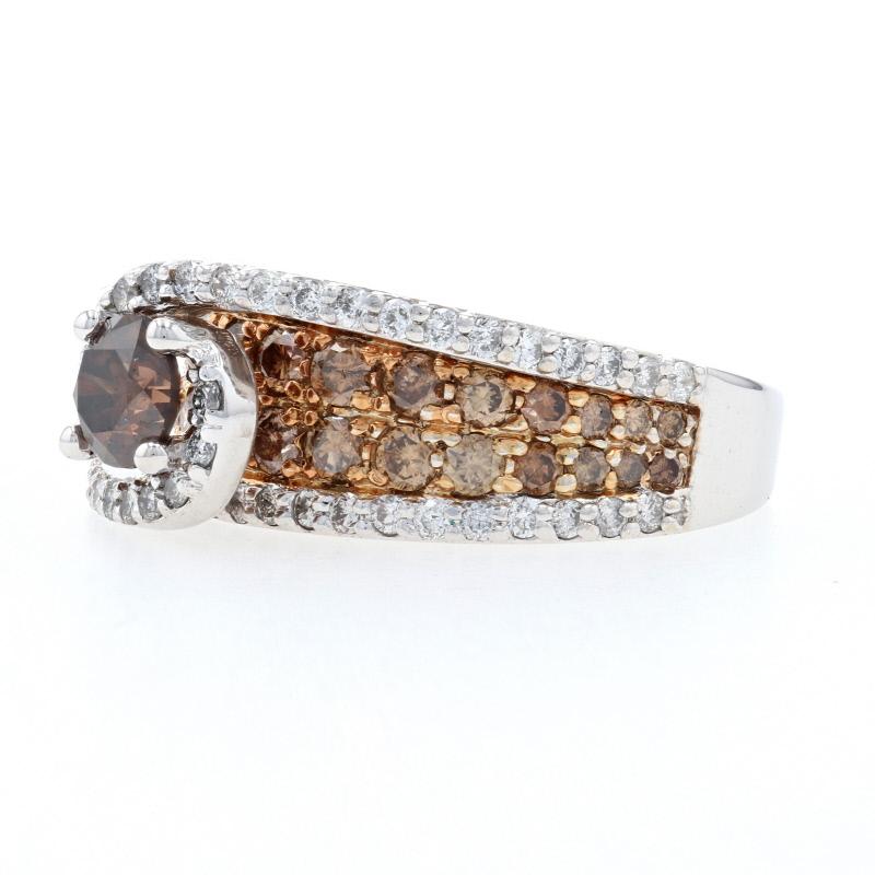 If you dream in diamonds, this exquisite treasure will delight! This 14k white and rose gold ring showcases a luxurious fancy brown diamond solitaire cradled by a swirling halo of white diamonds which cascade down the ring’s shoulders. Fancy