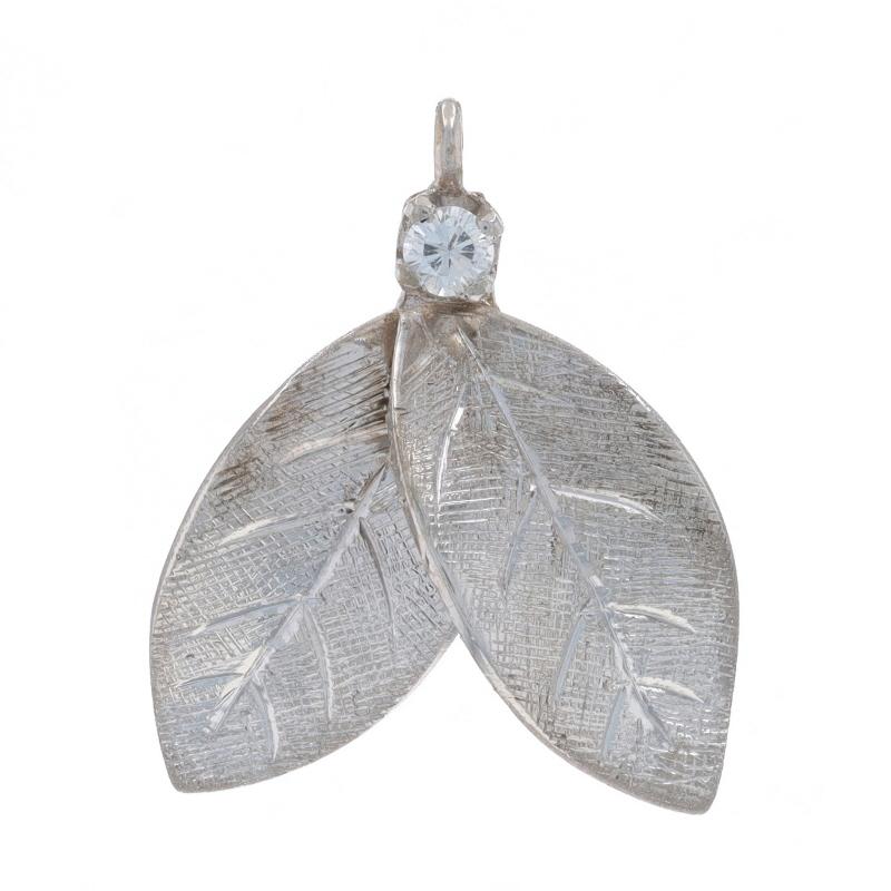 Metal Content: 14k White Gold

Stone Information

Natural Diamond
Carat(s): .04ct
Cut: Round Brilliant
Color: F
Clarity: SI1

Style: Solitaire
Theme: Pair of Leaves, Foliage
Features: Etched & Brushed Detailing

Measurements

Tall (from stationary