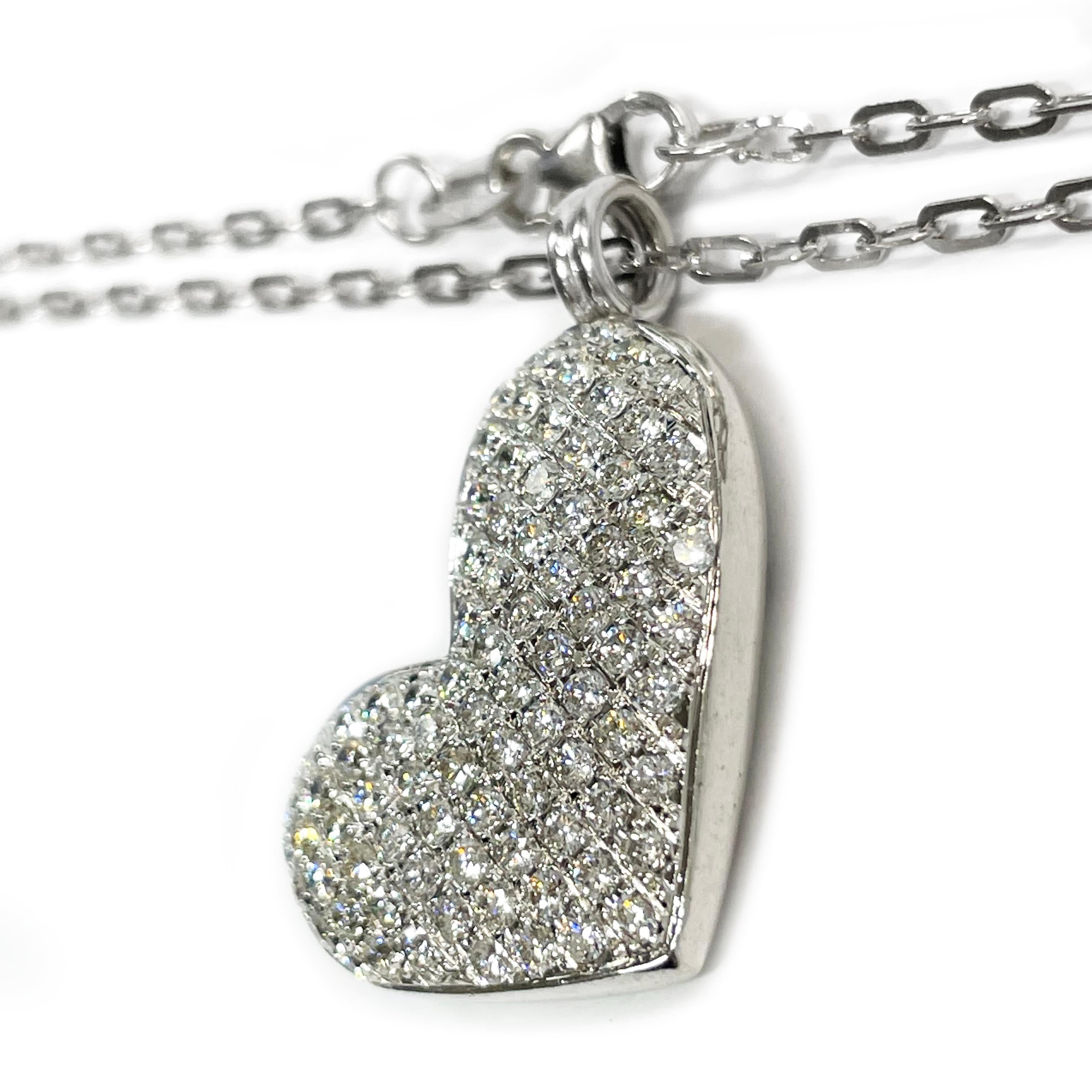 Collier en or blanc 14 carats avec pendentif en forme de cœur pavé de diamants. Le pendentif est en forme de cœur avec quatre-vingt-sept diamants ronds de 1,72 mm taillés en brillant et sertis en pavé, et une anse attachée. Les diamants ont un poids