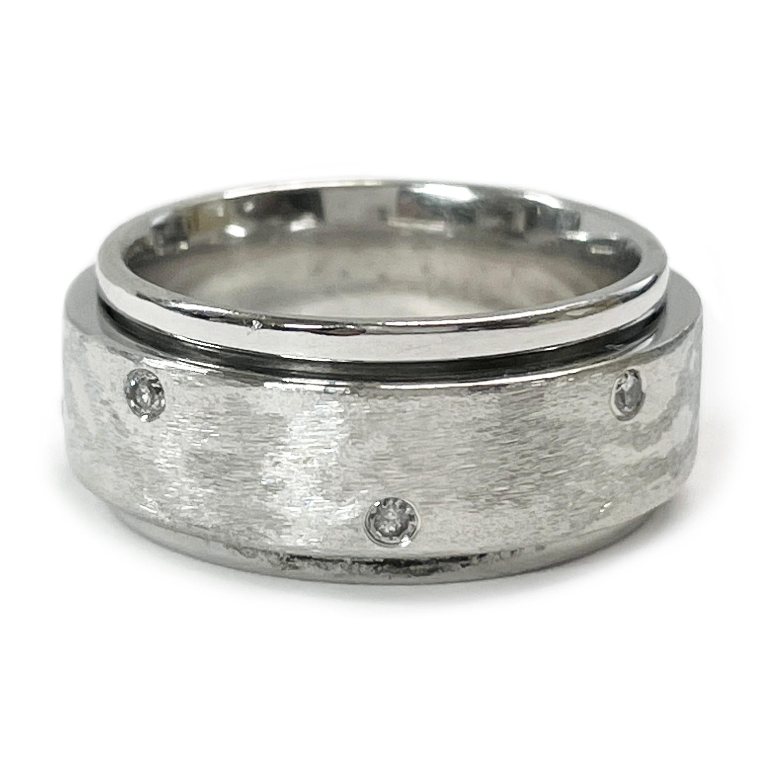 18 Karat White Gold Diamond Spinner Ring. The ring features a white gold wide band with a smooth shiny finish and a thinner spinner band with flush-set diamonds. There are a total of eight round diamonds set in a brushed finished band that spins.