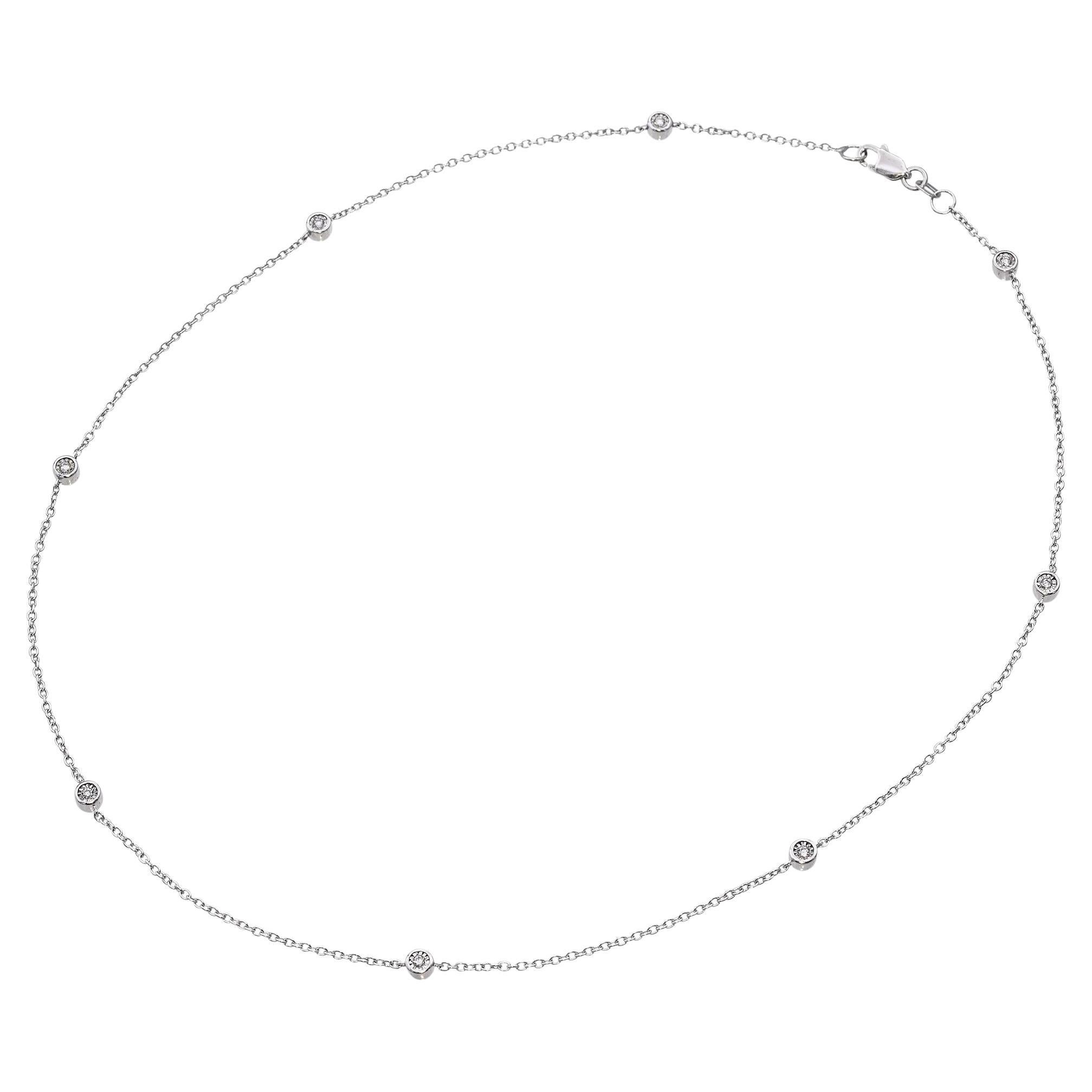 Este collar de estación vintage está elaborado en oro blanco y presenta diamantes engastados en bisel espaciados uniformemente a lo largo de una delicada cadena. El diseño minimalista ofrece un brillo refinado, perfecto para llevar a capas o solo.