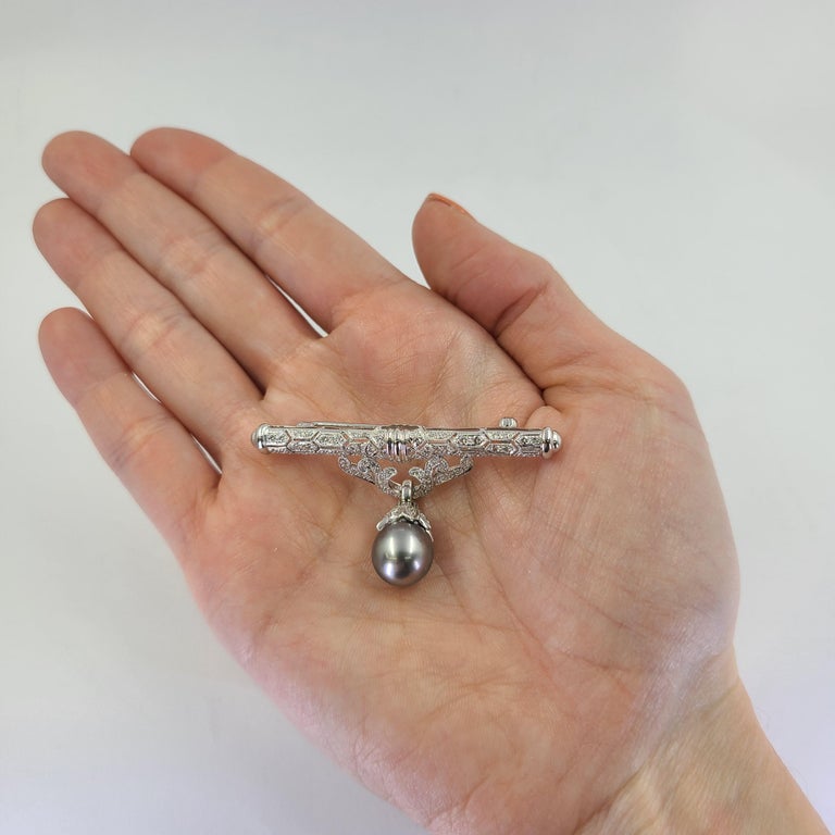 18 Karat White Gold Bar Pin Featuring A 10mm Gray Pearl Accented By 86 Round Diamonds Of VS/SI Clarity & G/H Color Totaling 1.00 Carat. 2 Inch Width. Finished Weight Is 9.2 Grams.