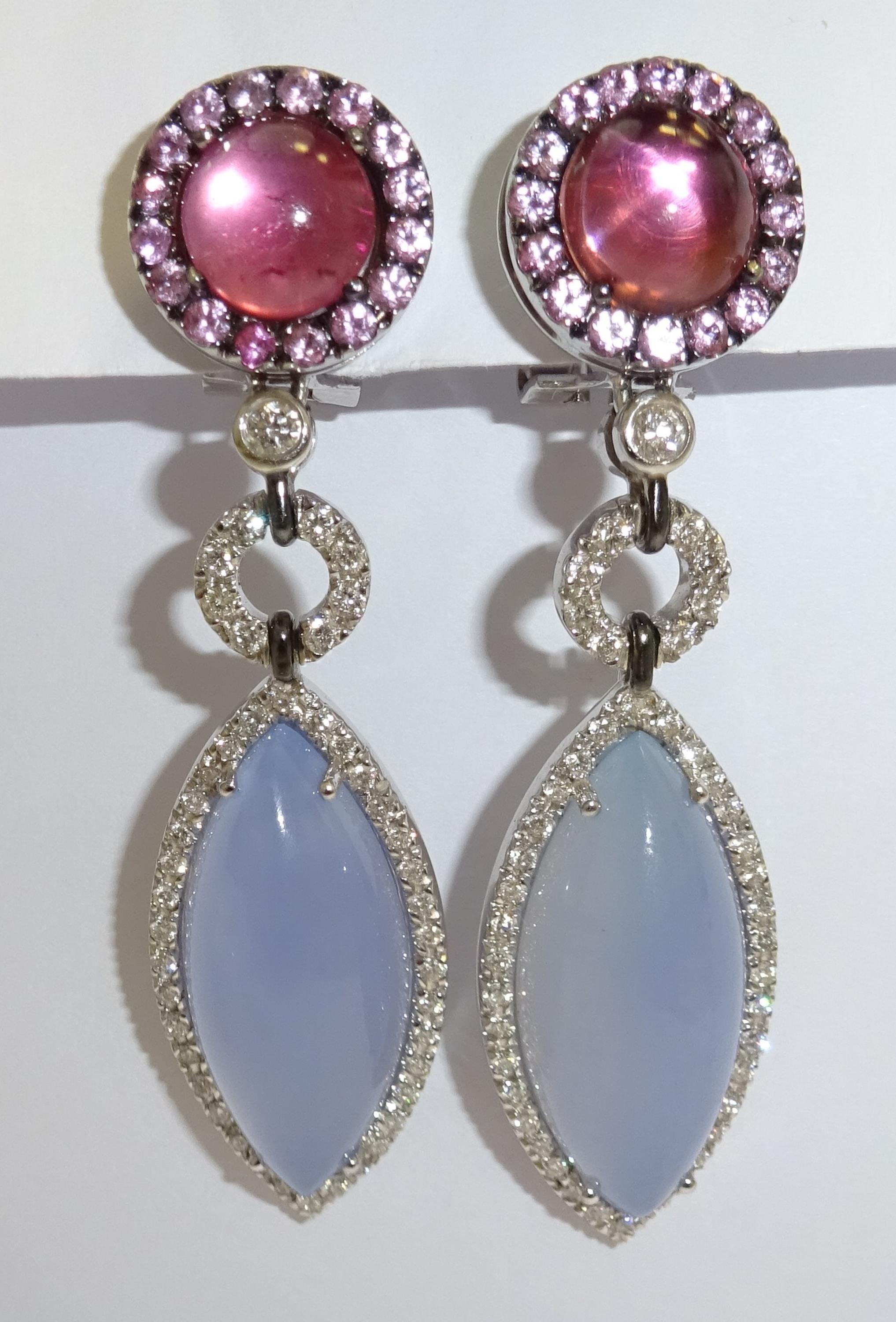 A magnificent pair of contemporary Diamond, Turmaline and Tanzanite drop Earrings. The earrings are mounted in 18 Karat white gold encrusted with vidid and truly stunning oval gemstones. These sensational earrings epitomize elegance and