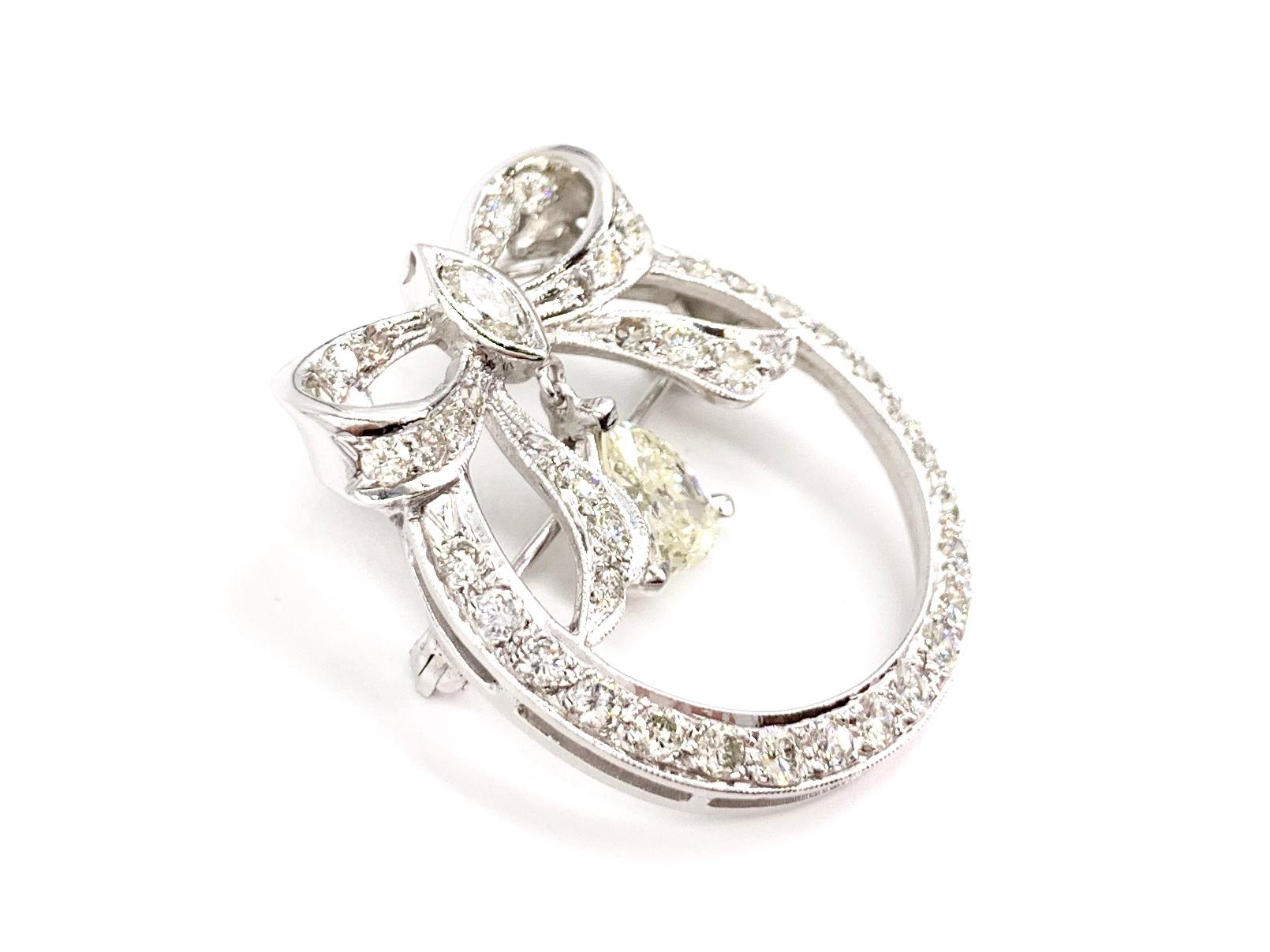 Beautiful Edwardian inspired 14 karat white gold and diamond vintage bow brooch that is fixed with two stationary jump rings so it can also be worn as a pendant - composed of approximately 2.50 carats diamond total weight. Open circle design