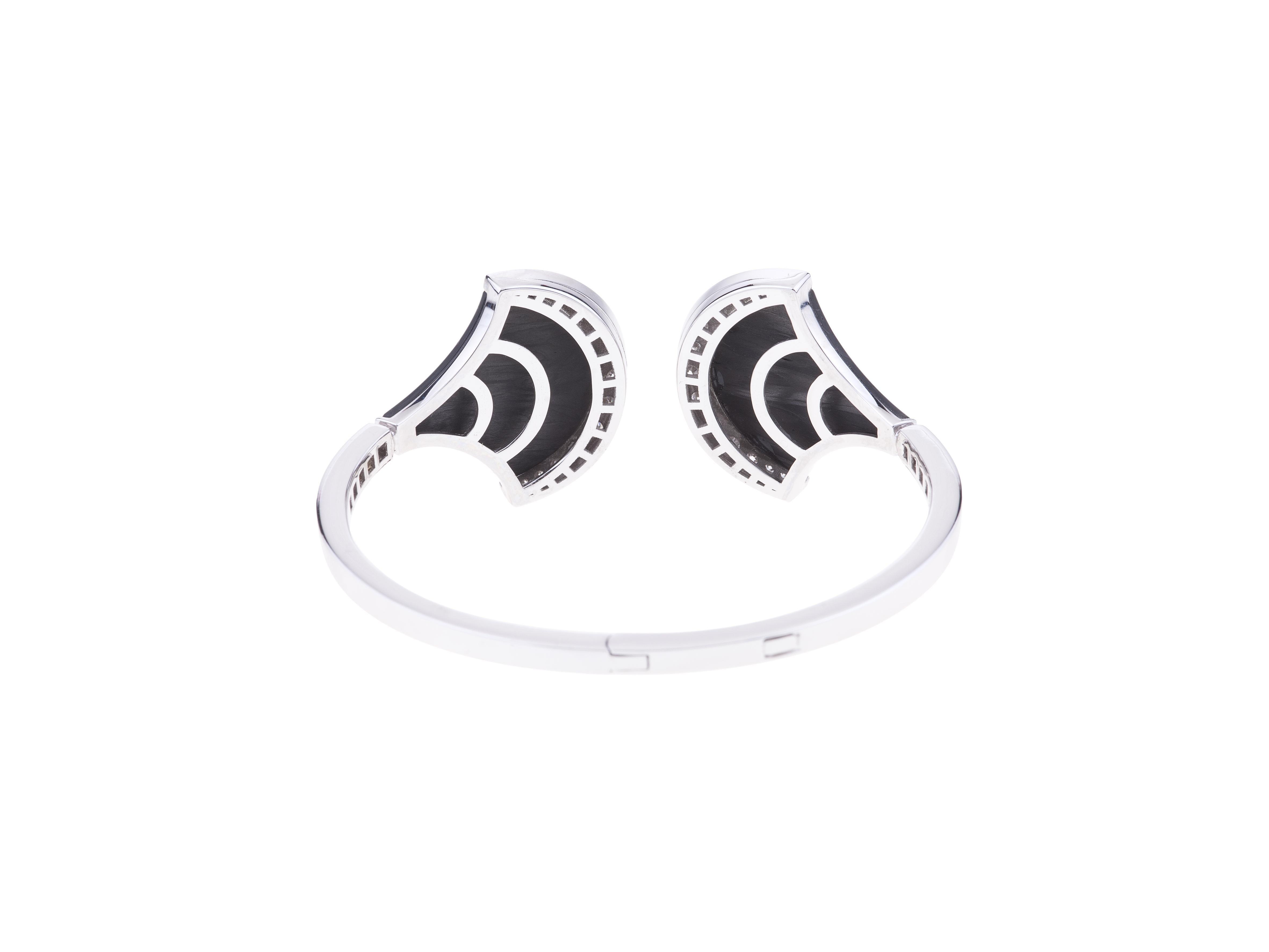 Pulsera brazalete Angeletti de oro blanco con diamantes y fibra de carbono negra.
El uso de nuevos materiales es una de las características de la inagotable vena creativa de Angeletti. La Fibra de Carbono engastada con diamantes confiere a este