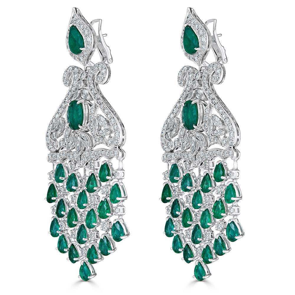 A pair of Chandelier Earrings hand crafted in 18K White Gold  and set with 10.05 carats of White Diamonds (G Color VS Clarity) and 19.60 carats Total Zambian Emeralds. These earrings are finished with a collapsable post and omega back that can be