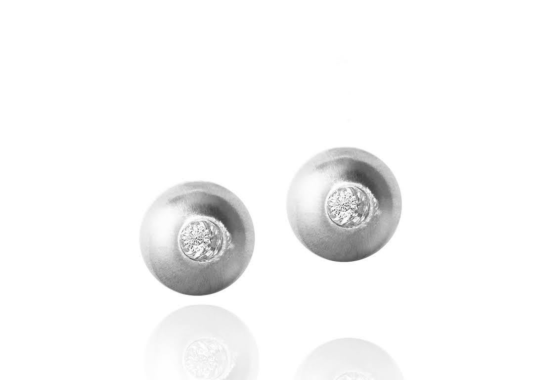 These White Sapphire in White Gold Dome Stud Earrings, part of our Power Series, are a symbolic design inspired by the idea of looking inward, the notion of what a person needs is already inside of them. The clean and classic lines are imaginative,