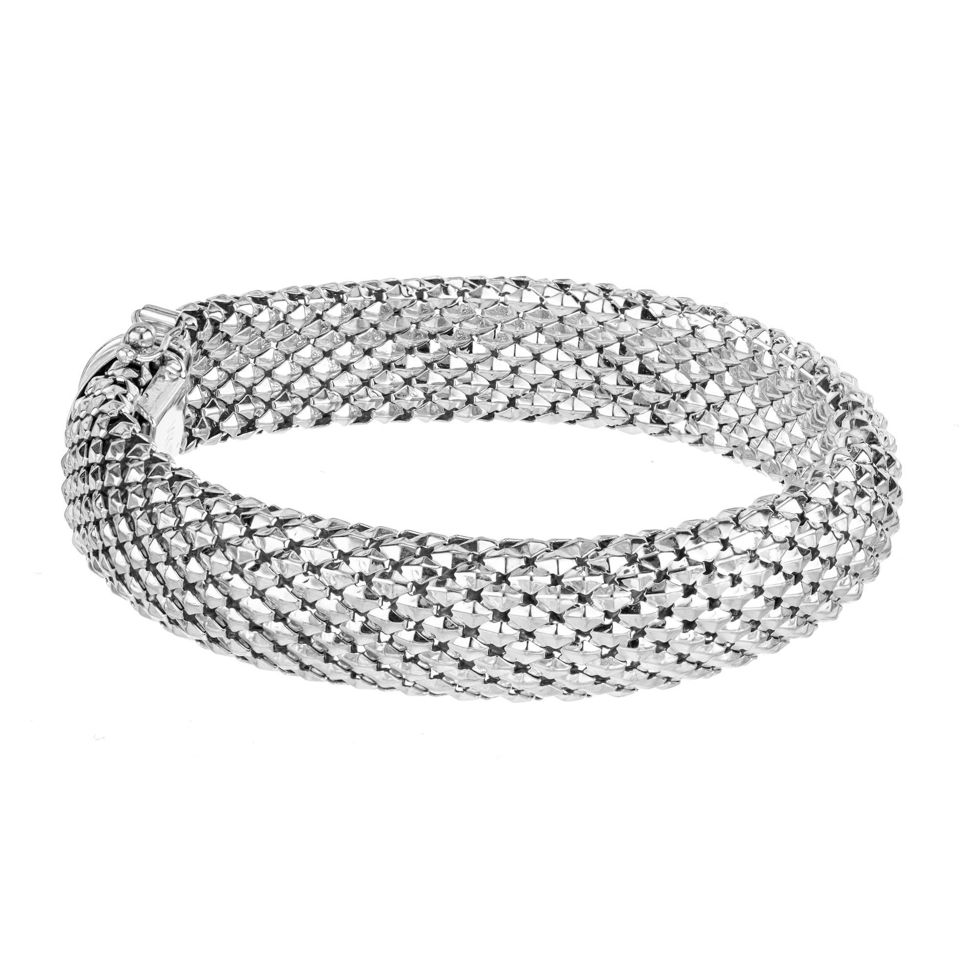 This wonderfully crafted 14k white gold 12.8mm wide domed textured 7.25 inch bracelet is a very modern stylish piece of jewelry. The bracelet features a unique textured design that adds depth and character while its width makes it a bold striking