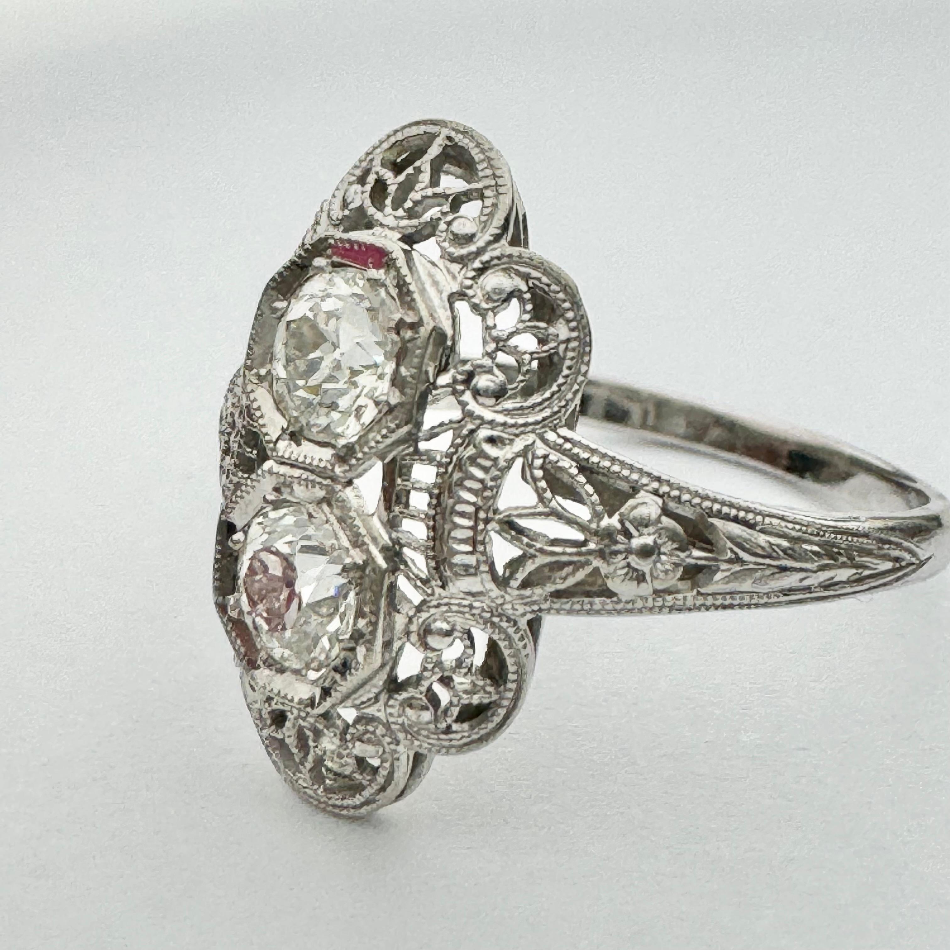 Uniquely beautiful antique style ring in 14k solid white gold. This beautiful ring features two stunning round brilliant old mine cut diamonds. This ring also showcases gorgeous and delicate antique filigree and milgrain designs. The beautiful pair