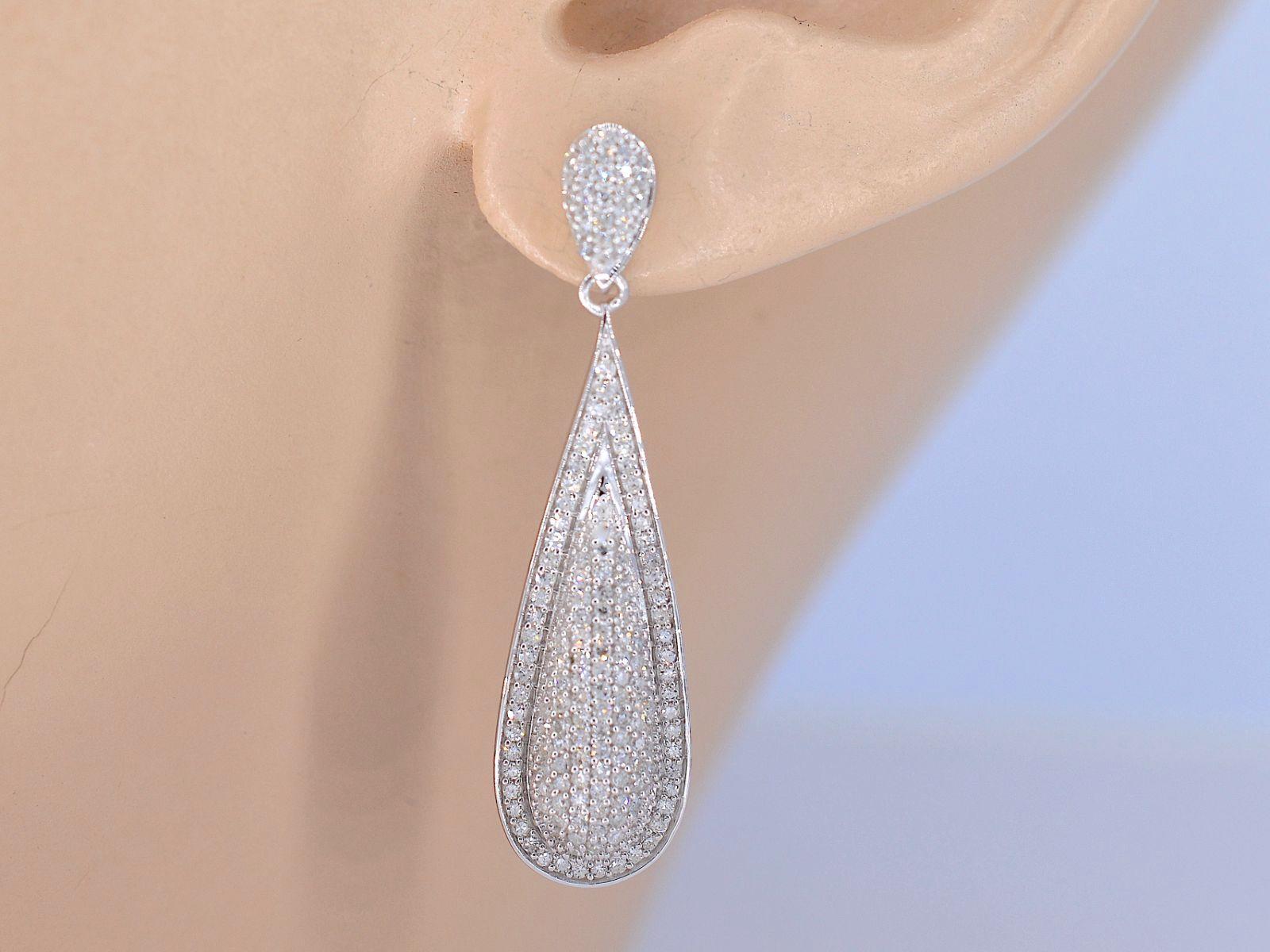 These stunning pair of white gold earrings are encrusted with brilliant Swiss cut diamonds that sparkle and shine in any lighting. The craftsmanship of these earrings is truly remarkable, with each diamond perfectly set to create a seamless and