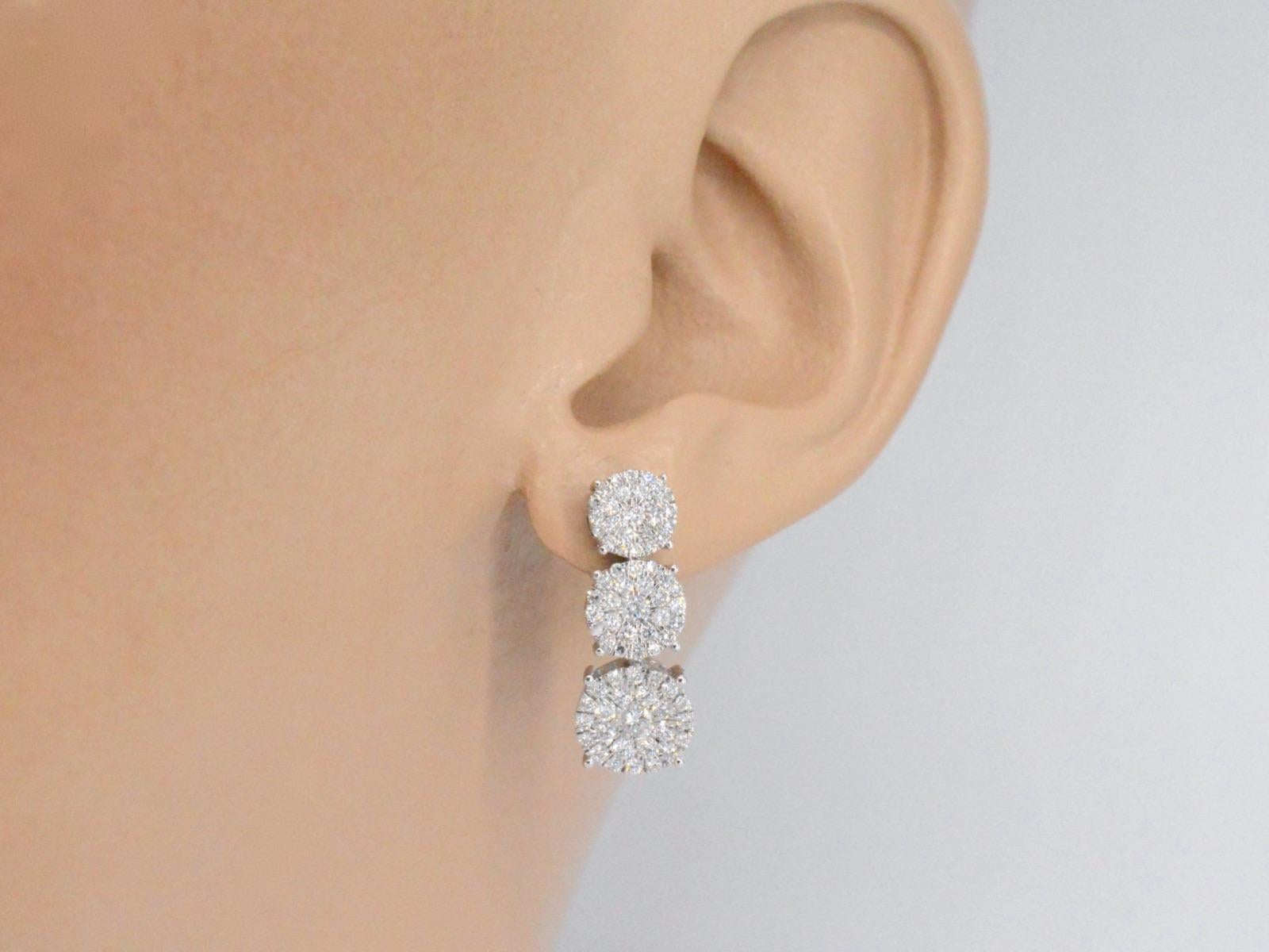These stunning white gold earrings feature a total of 1.40 carats of diamonds, arranged in a beautiful and unique design. Three chatons of diamonds are arranged below each other, creating a cascading effect that adds depth and dimension to the