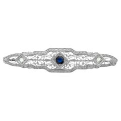 White gold Edwardian pin with center sapphire and 2 side accent diamonds