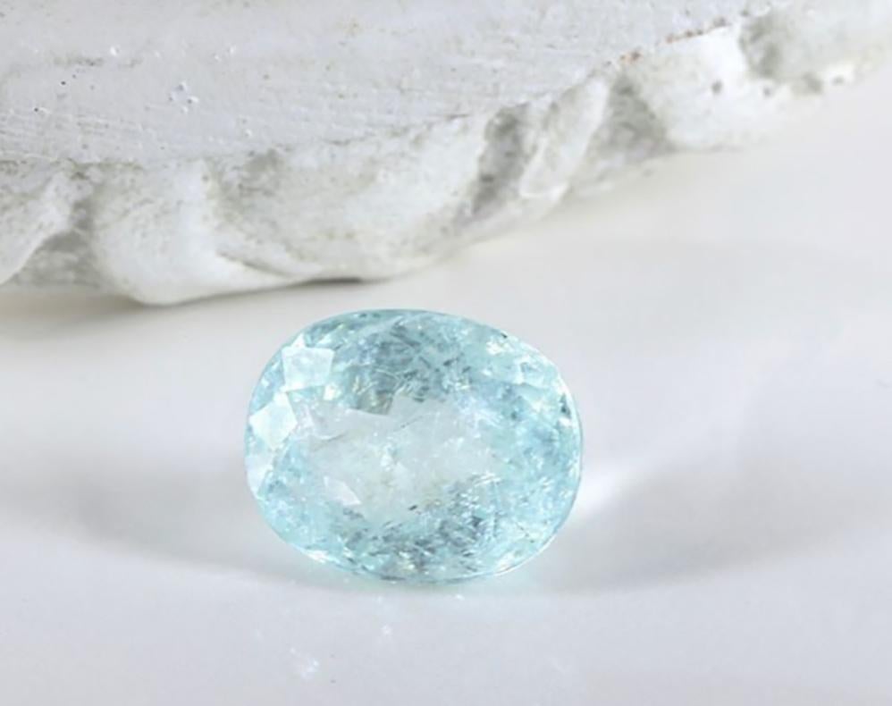 This contemporary Egyptian Revival engagement ring is in 18 karat white gold with natural untreated paraiba tourmaline, certified. The gem can be: oval cut transparent is 7.36 carats, 13.7x11 mm, oval cut sugar-clouds 6.17 carats 12.5x10 mm, or