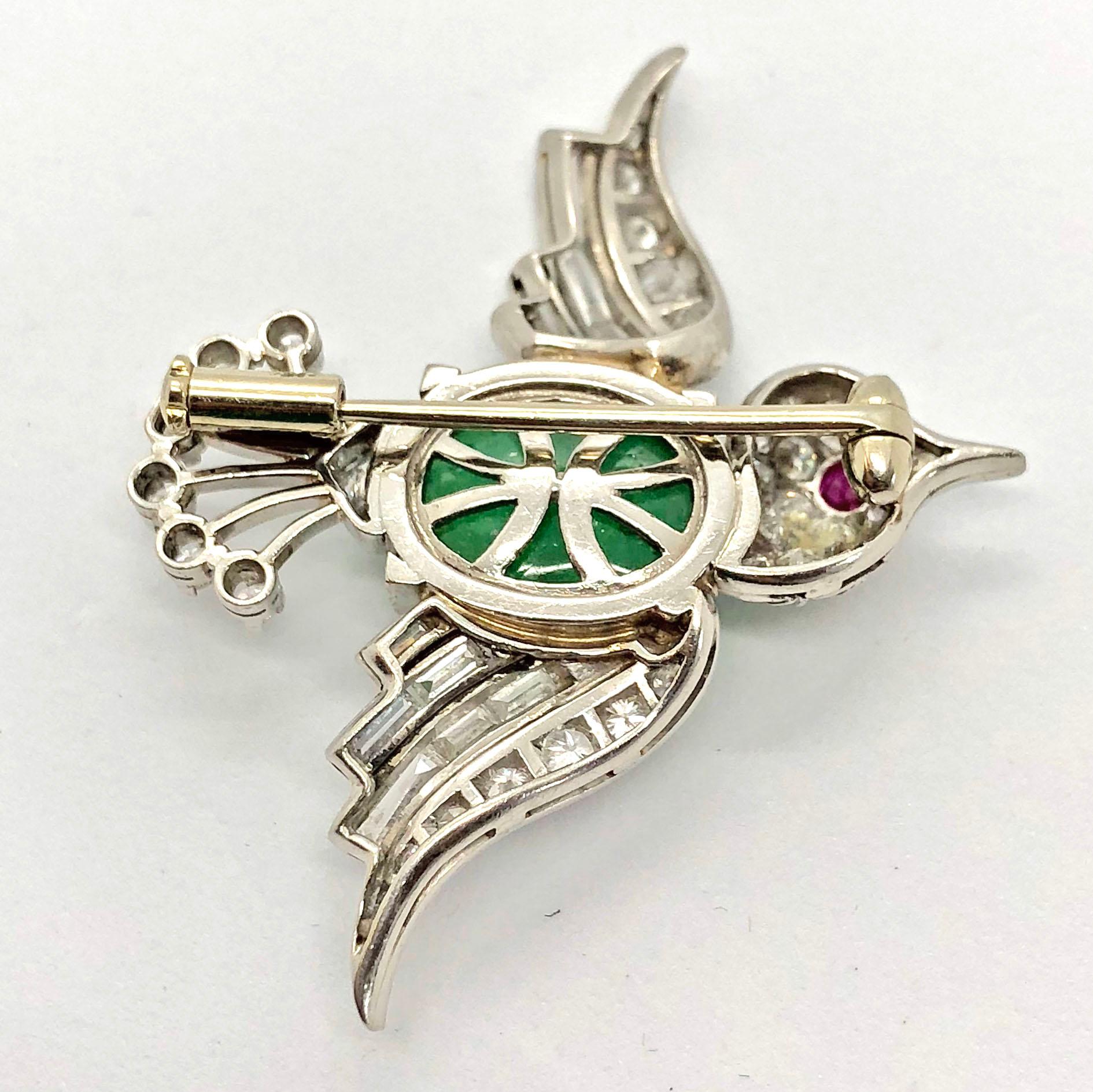 A cute late Art Deco bird brooch, circa 1940s. The bird body centres an emerald cabochon, weighing ca. 6 carats. The eye is made out of a ruby cabochon and the feathers and head of the bird are artistically studded with diamond round brilliants,