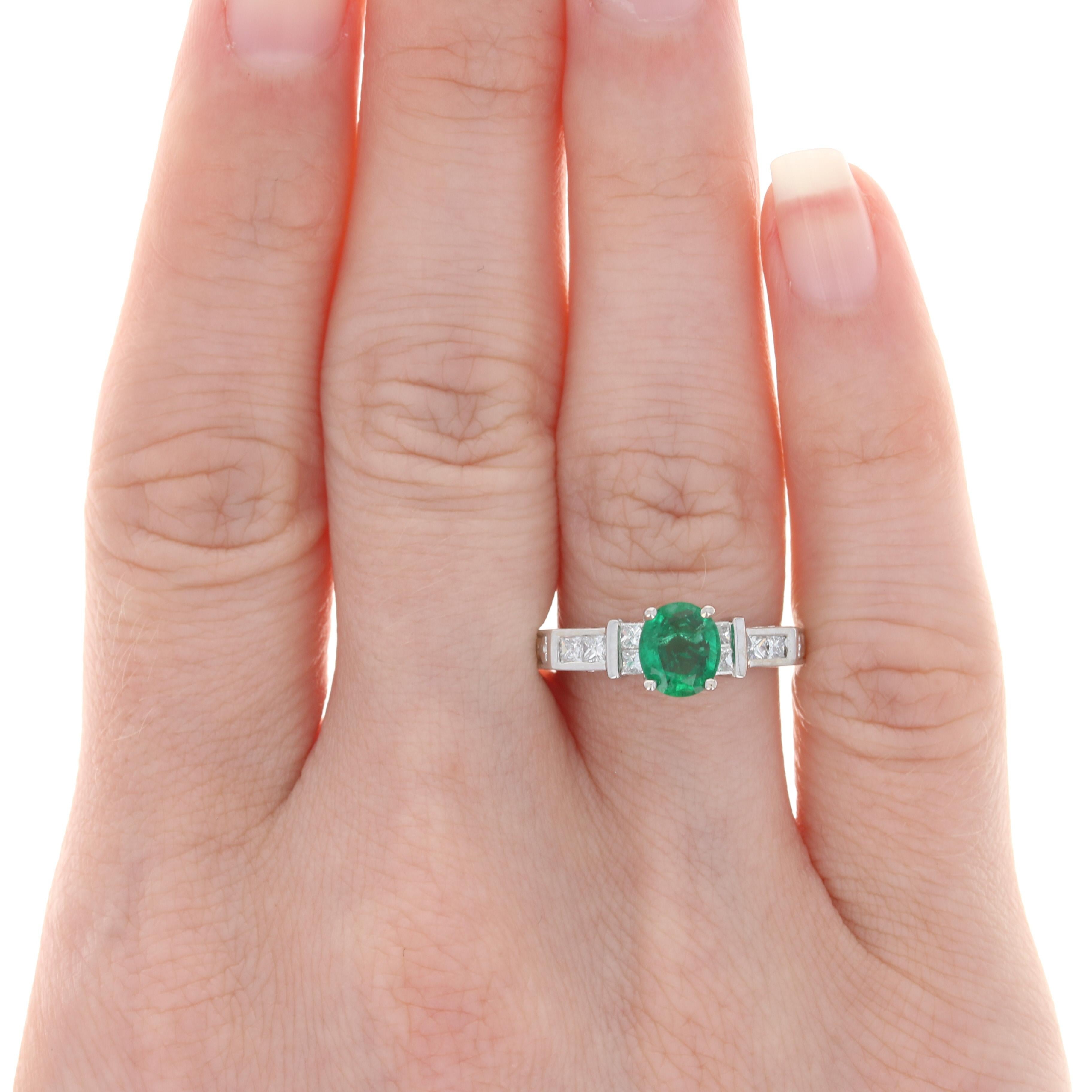 Size: 6 1/2

Metal Content: 18k White Gold

Stone Information: 
Genuine Emerald
Treatment: Oiling
Carat: .97ct
Cut: Oval
Color: Green
Size: 6.8mm X 5.9mm

Natural Diamonds
Carats: .32ctw
Cut: Princess 
Color: G - H
Clarity: SI1 - SI2

Total Carats: