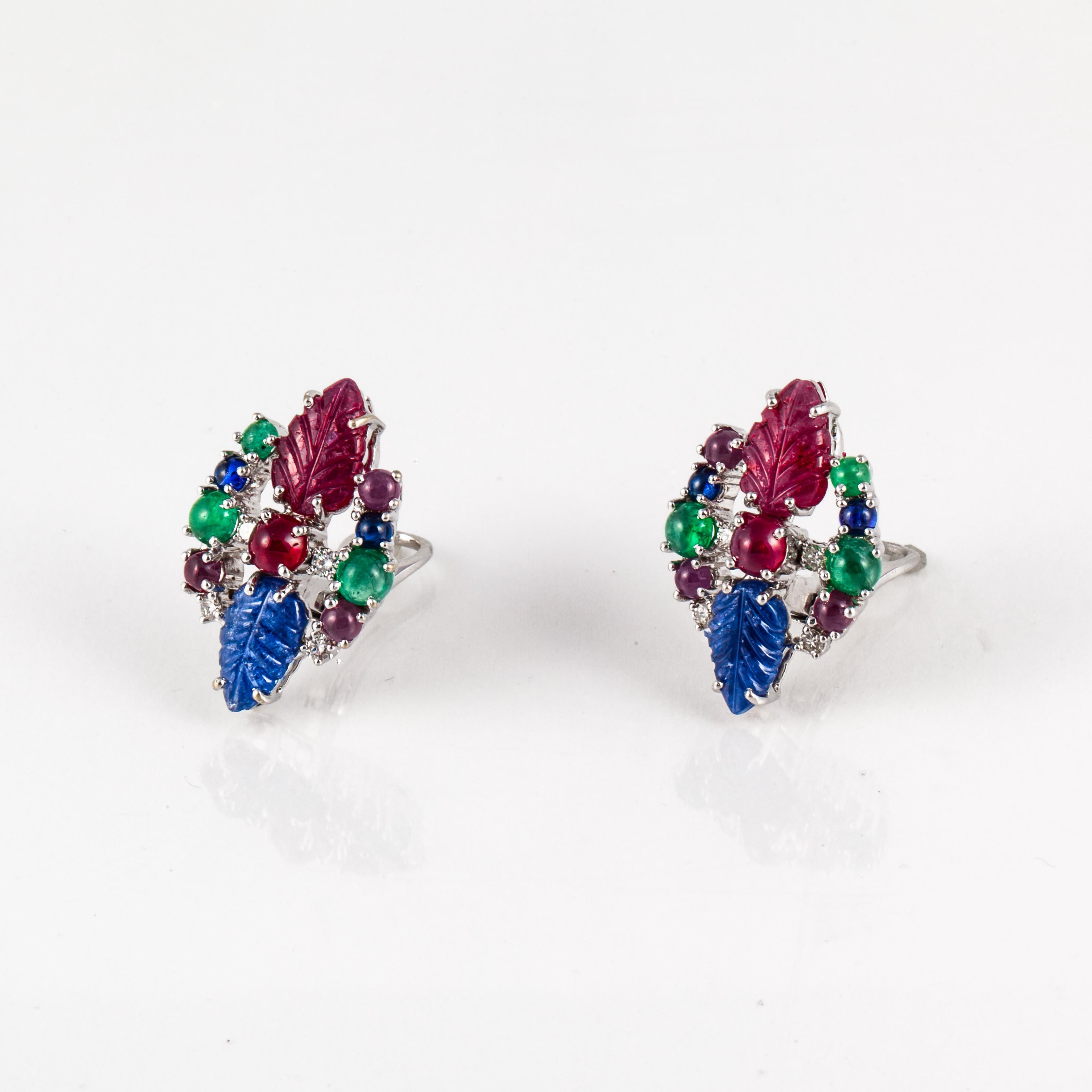 Art Deco tutti-frutti style earrings in 18K white gold with cabochon emeralds, rubies and sapphires and accented by round diamonds.   Total diamond weight is 0.65 carats.  They have drop down posts with clip backs.  Measure 1 1/8 inches by 3/4