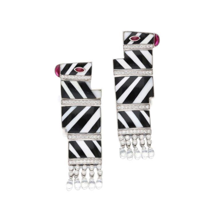 Designed as zebras, accented by rock crystal quartz, round brilliant - cut diamonds and rubies. 
- Diamonds weighing a total of approximately 1.20 carats 
- Signed Khan Mutlu
 - 18 karat white gold 
- Total weight 40.40 grams
 - Length 2¼ inches,