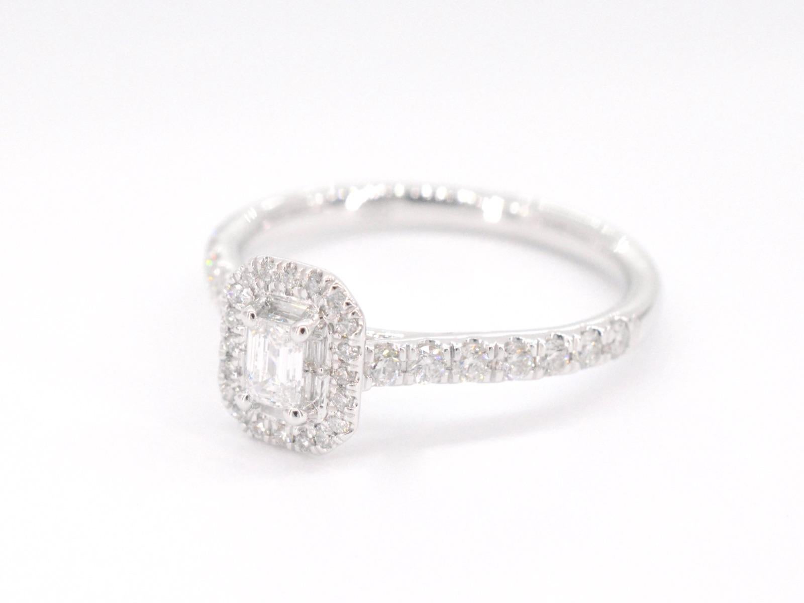 A white gold entourage ring with a center baguette cut stone and brilliant cut diamonds is a stunning piece of jewelry that combines classic and modern elements. The baguette cut stone is surrounded by smaller, sparkling diamonds that enhance its
