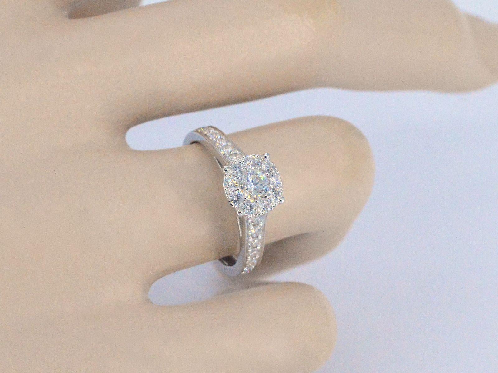 Une bague entourage en or blanc de haute qualité avec des diamants taille brillant de 1,00 carat est un bijou luxueux qui présente un magnifique diamant central entouré de diamants plus petits. La bague est fabriquée en or blanc de haute qualité, ce