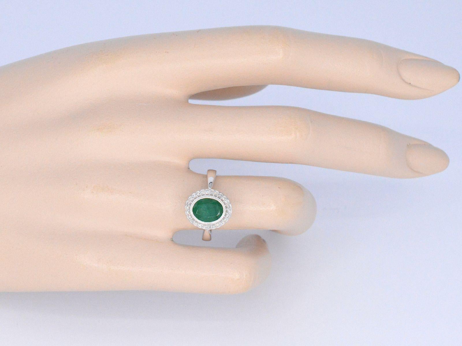 Contemporary White gold entourage ring with diamonds and emerald For Sale